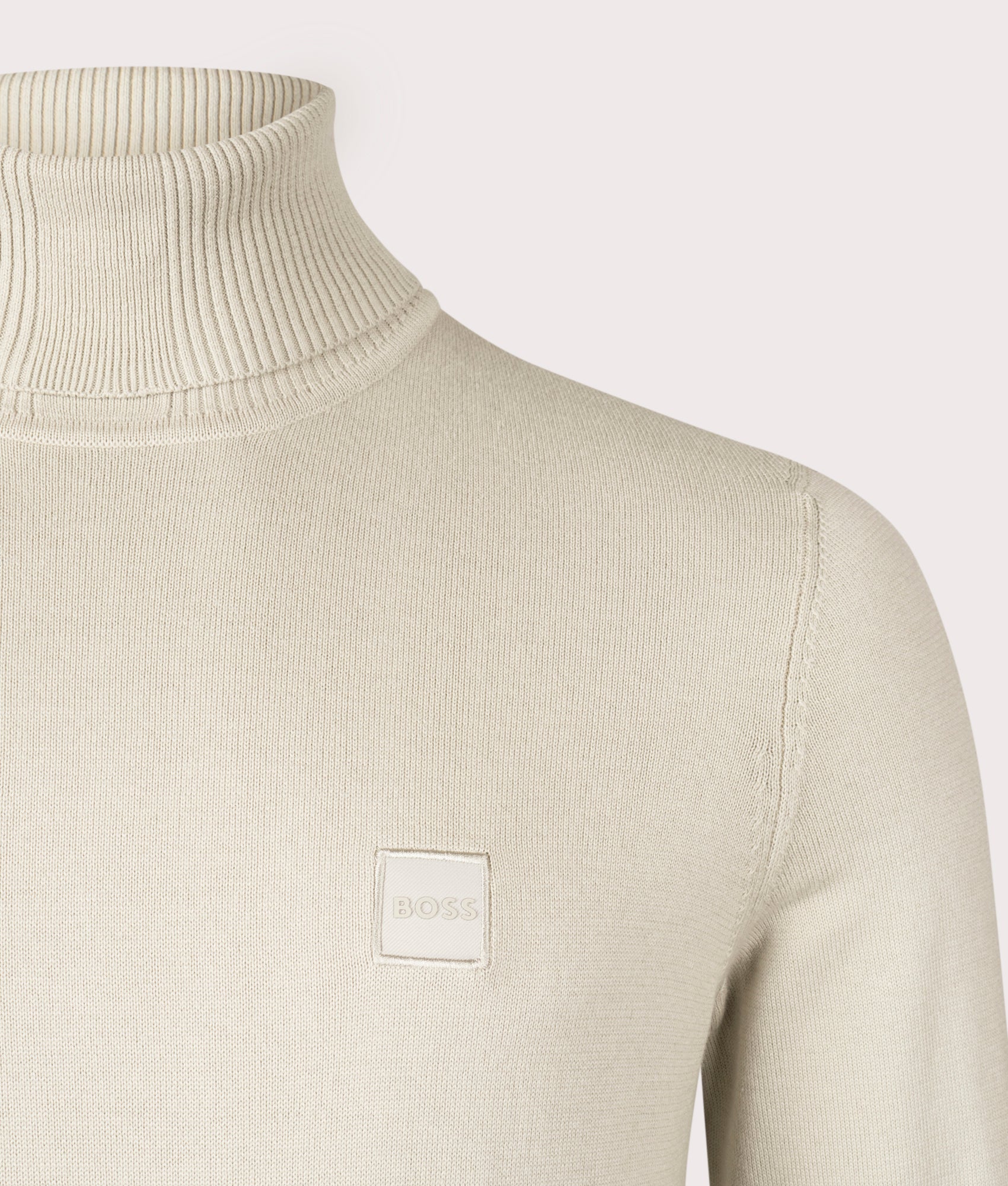 BOSS Akiro Rollneck Jumper in Light Beige, Cotton/Cashmere Blend. At EQVVS Menswear. Front logo shot