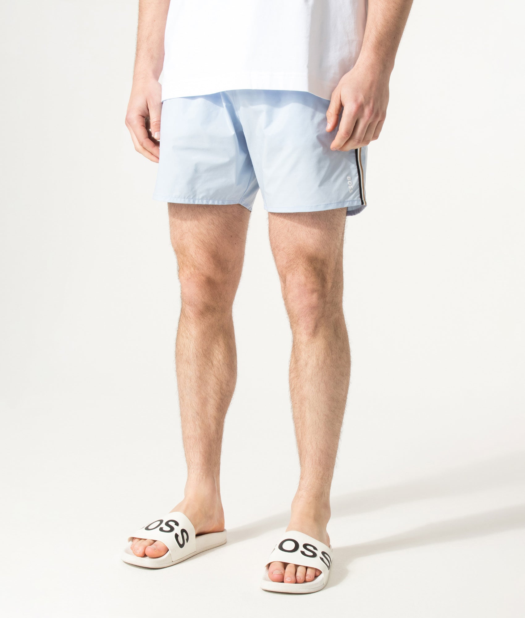 BOSS Iconic Swim Shorts in Light/Pastel Blue at EQVVS Menswear. Angled model front shot.