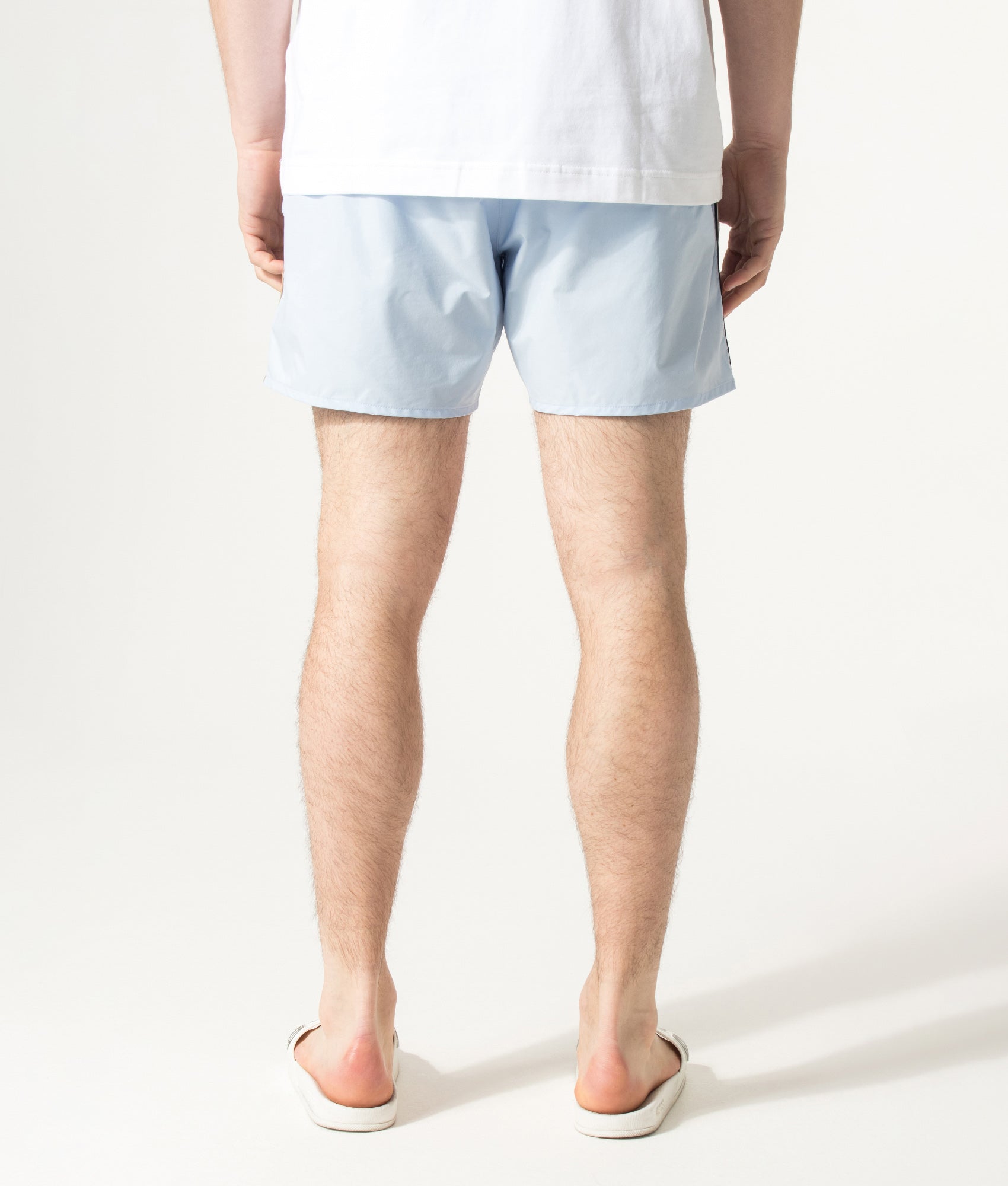 BOSS Iconic Swim Shorts in Light/Pastel Blue at EQVVS Menswear. Angled model front shot.
