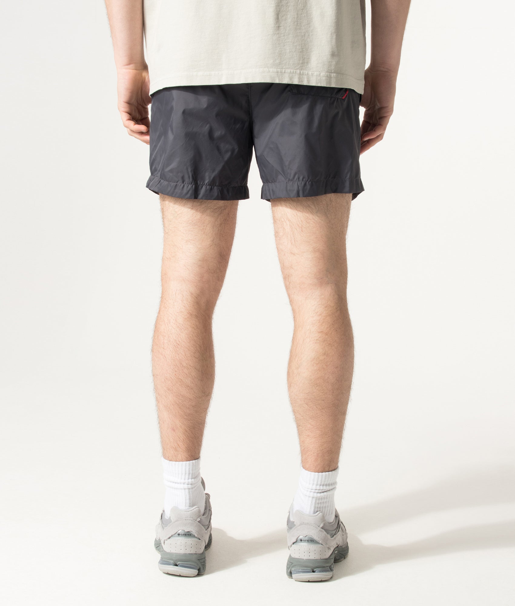 HUGO HAITI Swim Shorts in Charcoal at EQVVS Menswear. Angled model back shot.