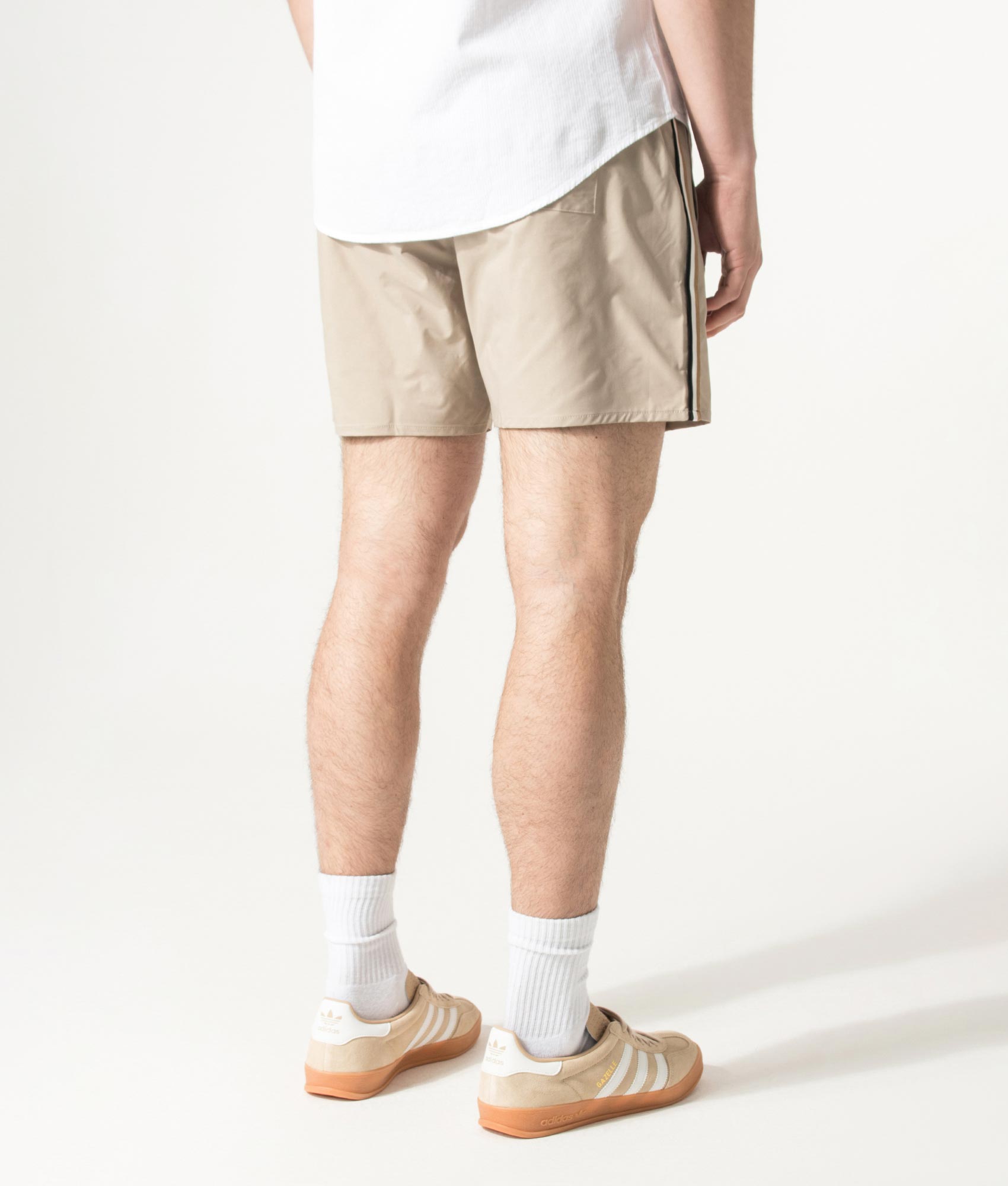 BOSS Iconic Swim Shorts in Light Beige at EQVVS Menswear. Angled model front shot.