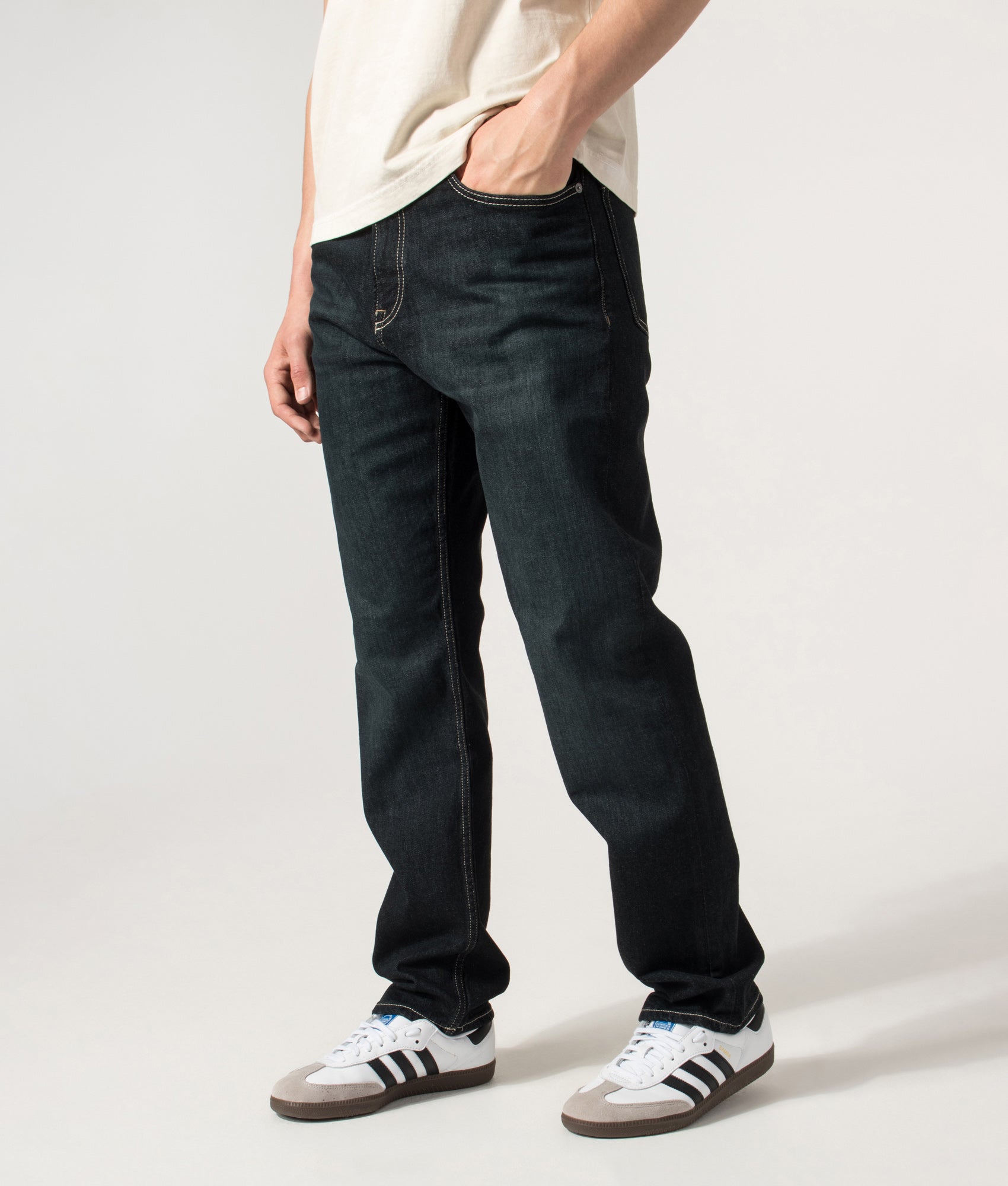 BOSS Ogden 3 Straight Leg Jeans in Dark Blue at EQVVS Menswear. Angled front shot.