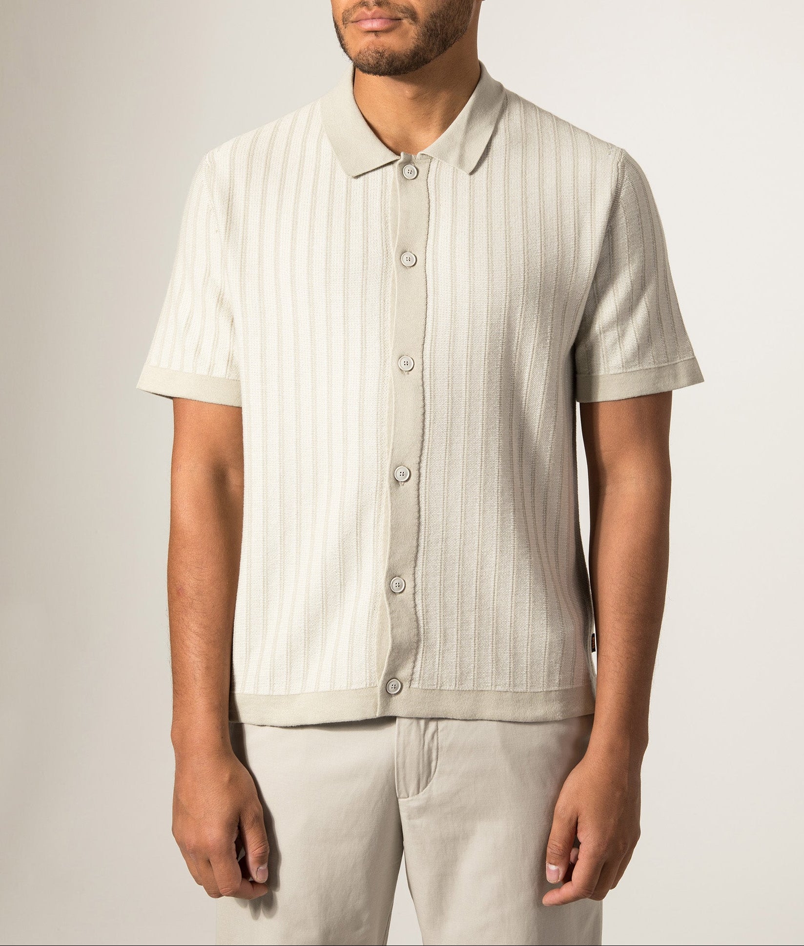 BOSS Relaxed Fit Kodd Knitted Polo Shirt in Light Beige at EQVVS Menswear. Model front shot.