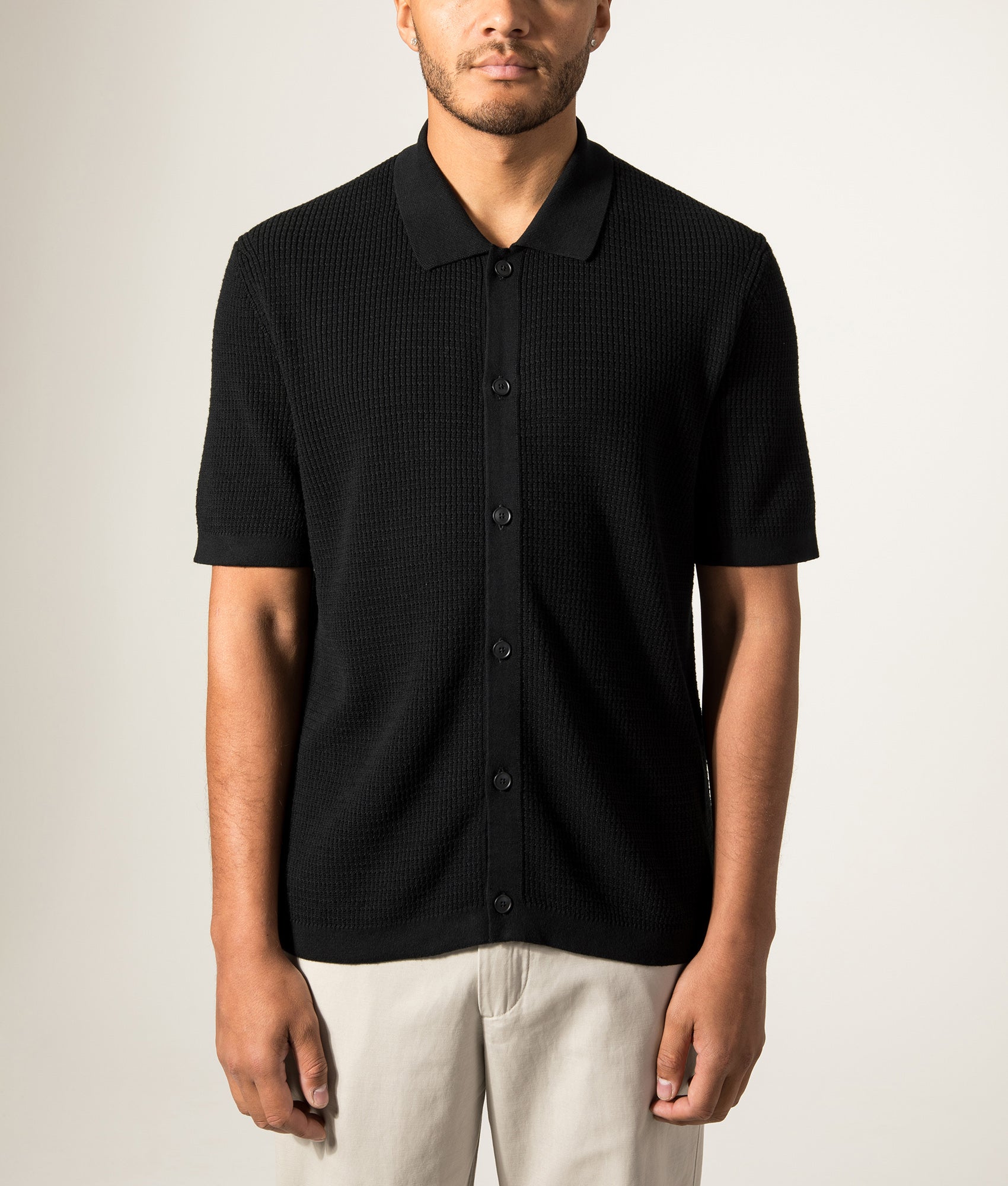 BOSS Relaxed Fit Akepalo Knitted Polo Shirt in Black at EQVVS Menswear. Model front shot.
