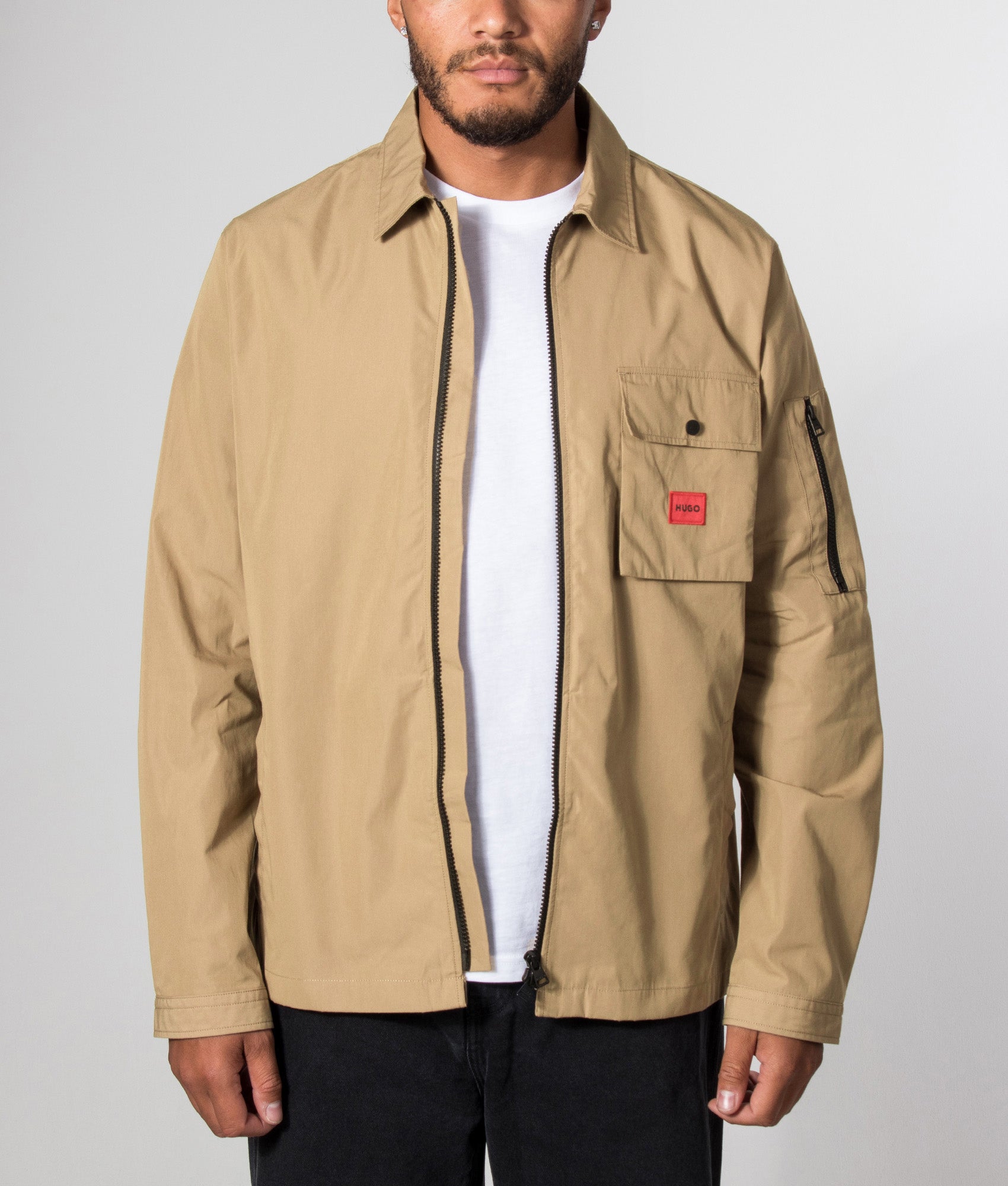 HUGO Relaxed Fit Emmond Zip Through Overshirt in Beige Overflow at EQVVS Menswear. Model front shot.