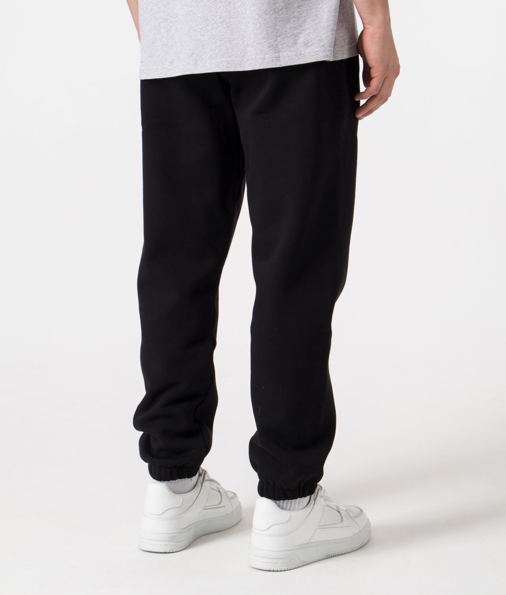 Carhartt WIP Relaxed Fit Chase Joggers in Black with Gold Carhartt 'C' Back Shot at EQVVS