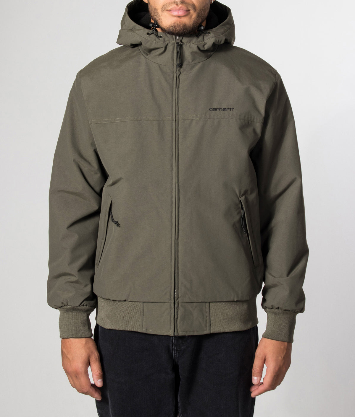 Carhartt WIP Regular Fit Hooded Sail Jacket in Cypress and Black at EQVVS Menswear. Model front shot.