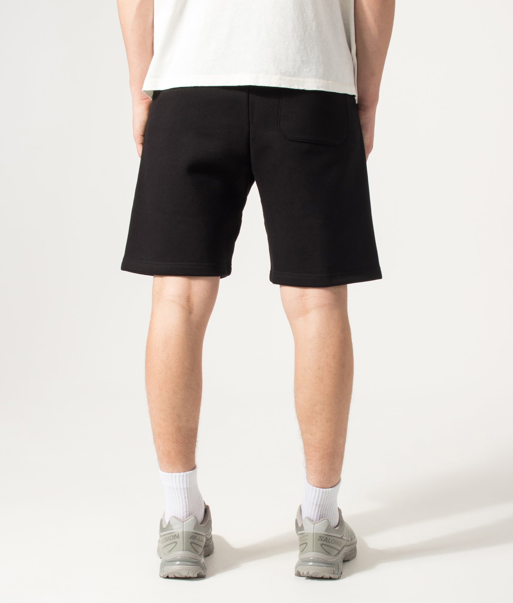 Carhartt WIP Loose Fit Chase Sweat Shorts in Black and Gold at EQVVS Menswear. Back shot.
