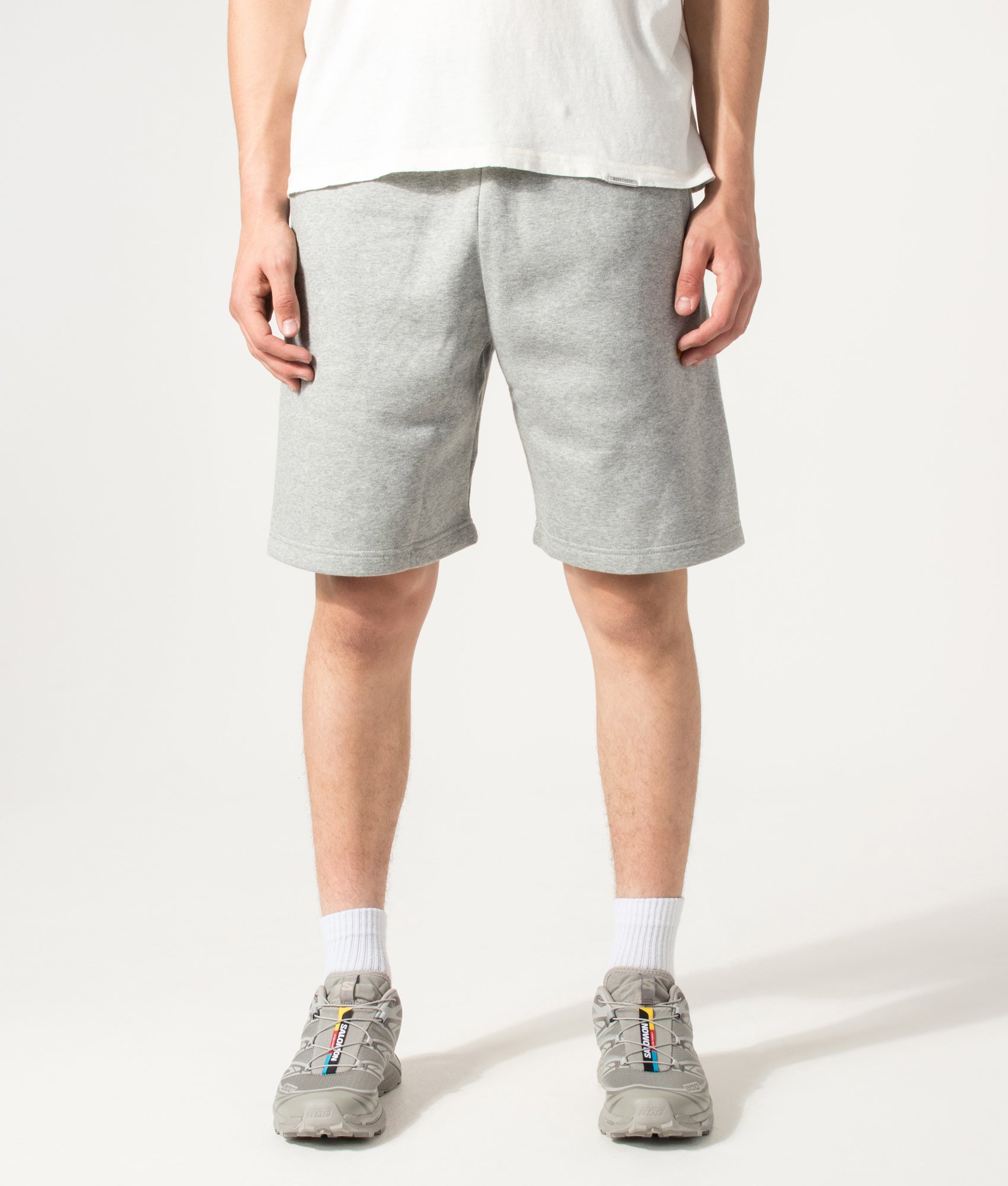 Carhartt WIP Loose Fit Chase Sweat Shorts in Grey Heather and Gold at EQVVS Menswear. Model Front shot.