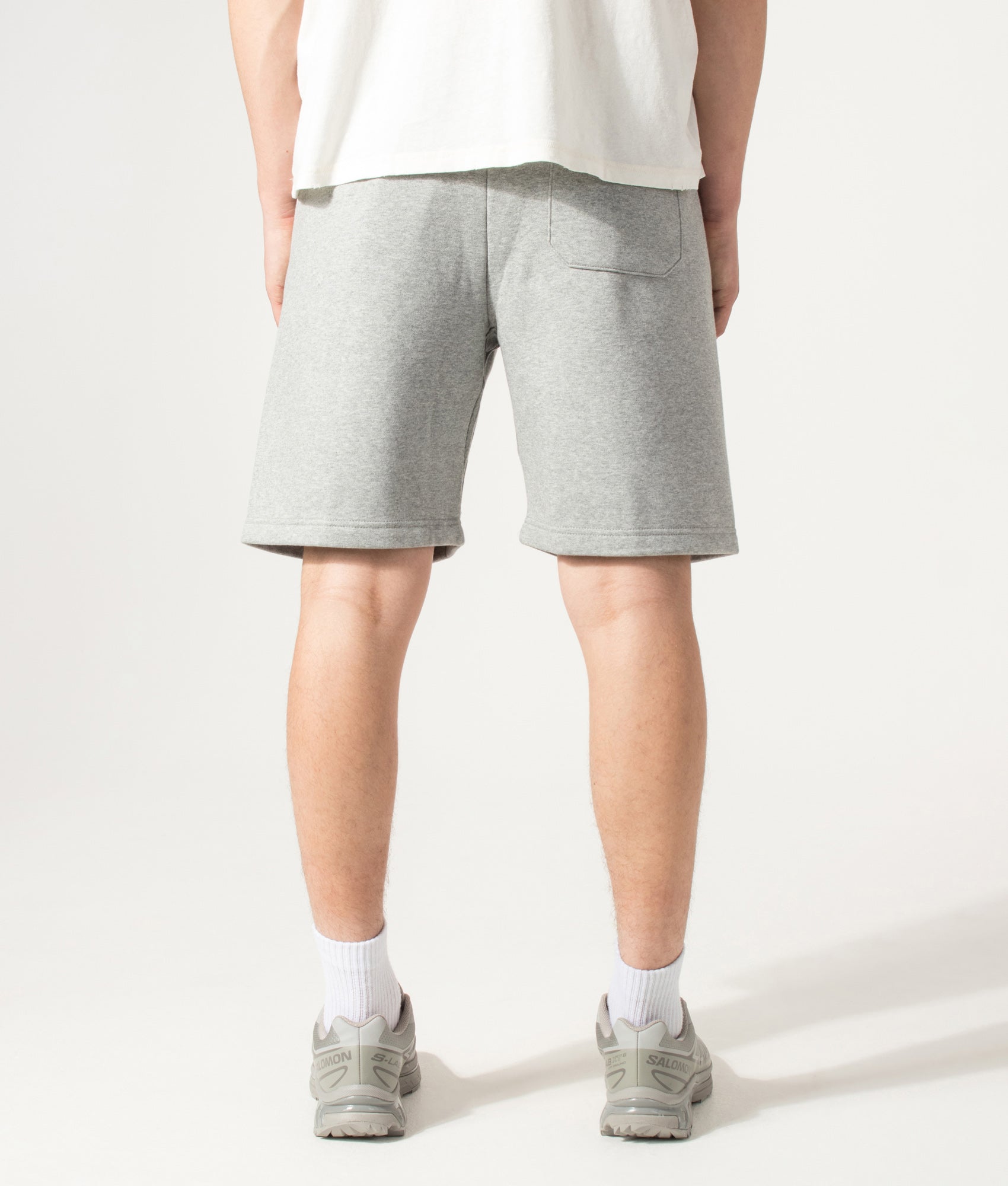Carhartt WIP Loose Fit Chase Sweat Shorts in Grey Heather and Gold at EQVVS Menswear. Model back shot.