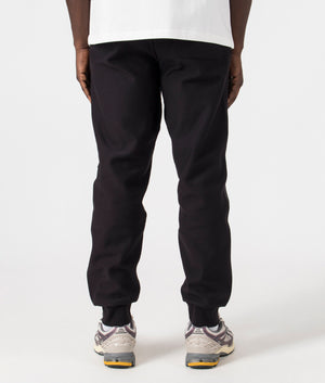 Carhartt WIP Relaxed Fit American Script Joggers in Black. Back angle model shot at EQVVS.