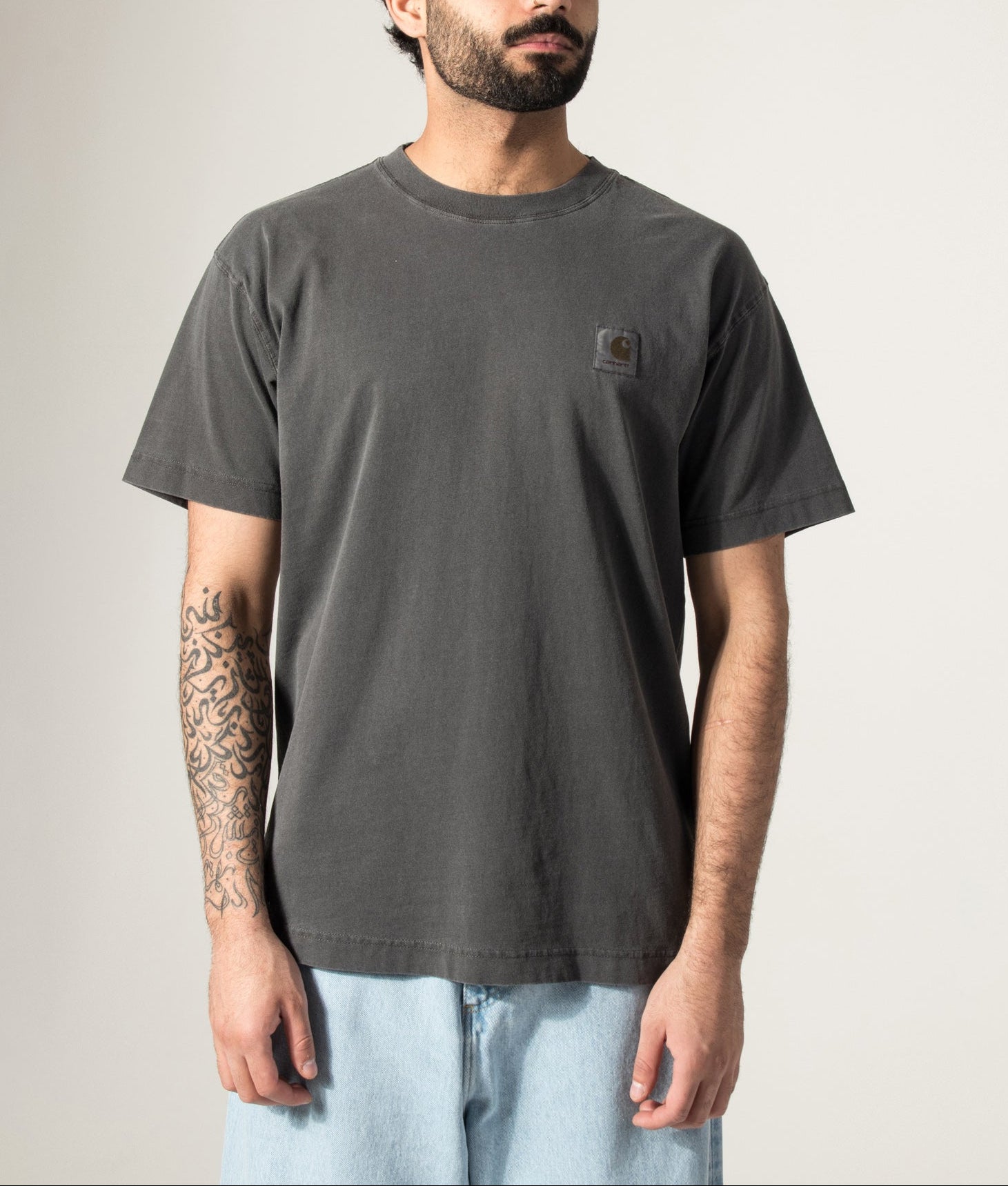 Carhartt WIP Relaxed Fit Nelson T-Shirt in Black at EQVVS Menswear. Model front shot.