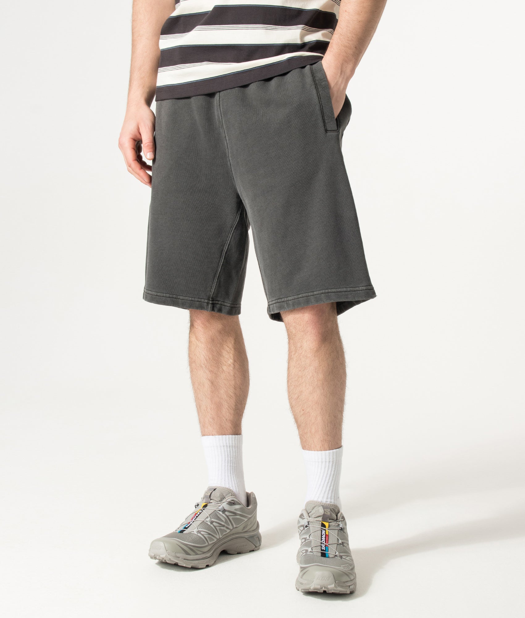 Carhartt WIP Balloon Fit Nelson Sweat Shorts in Black at EQVVS Menswear. Angled model front shot.