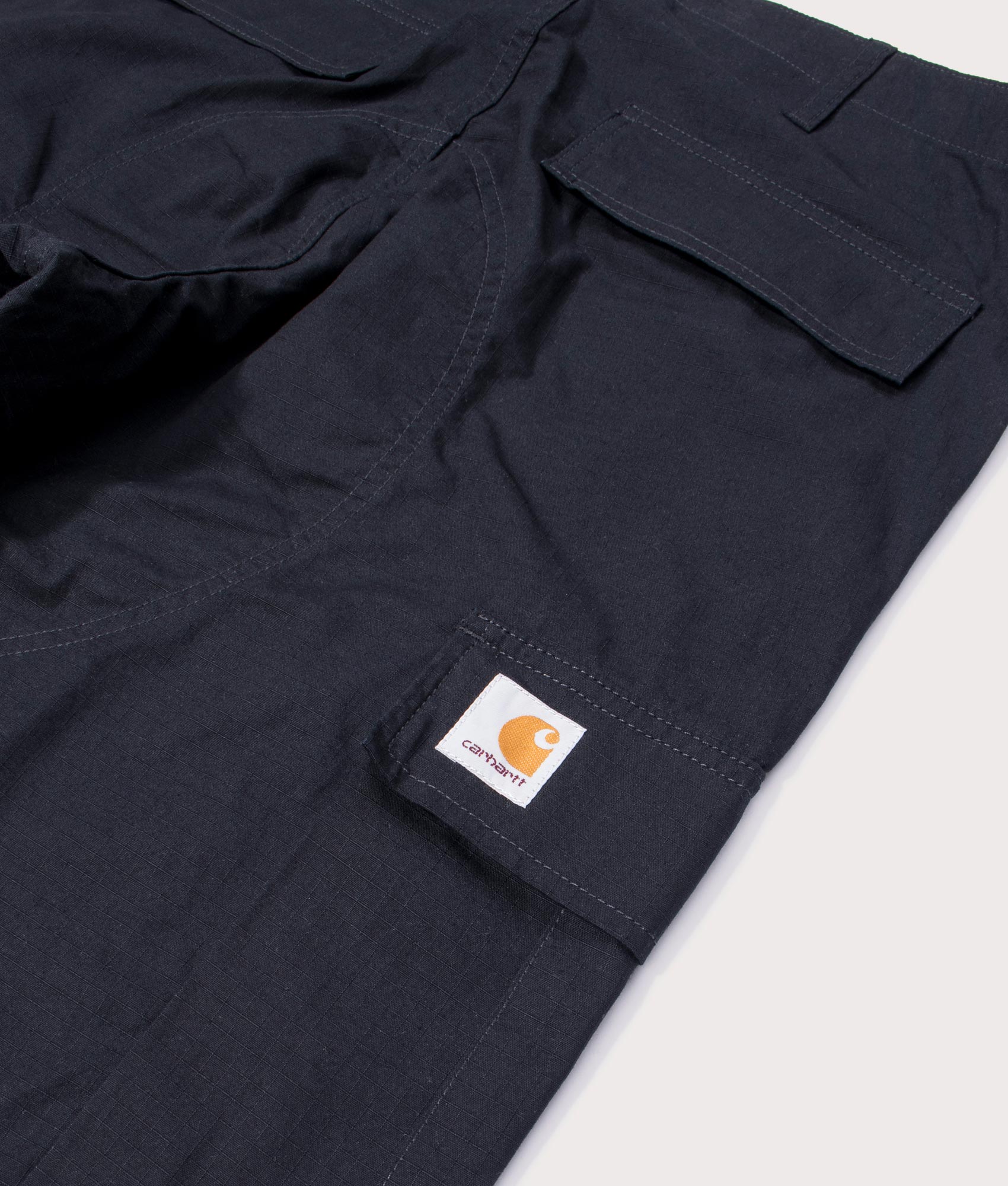 Carhartt Regular Fit Cargo Pants in Black at EQVVS Menswear. Flat detail shot.
