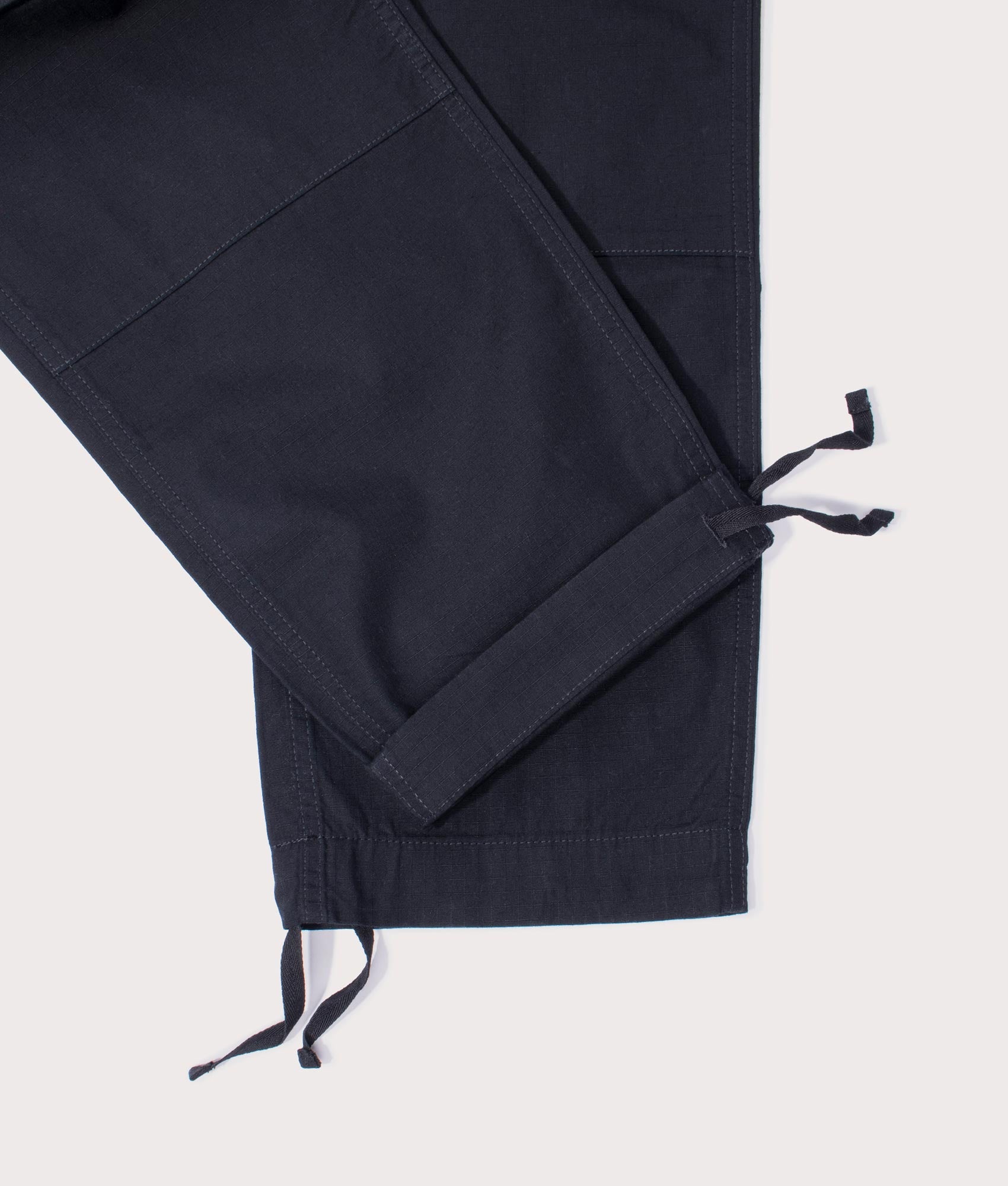 Carhartt Regular Fit Cargo Pants in Black at EQVVS Menswear. Detail shot.