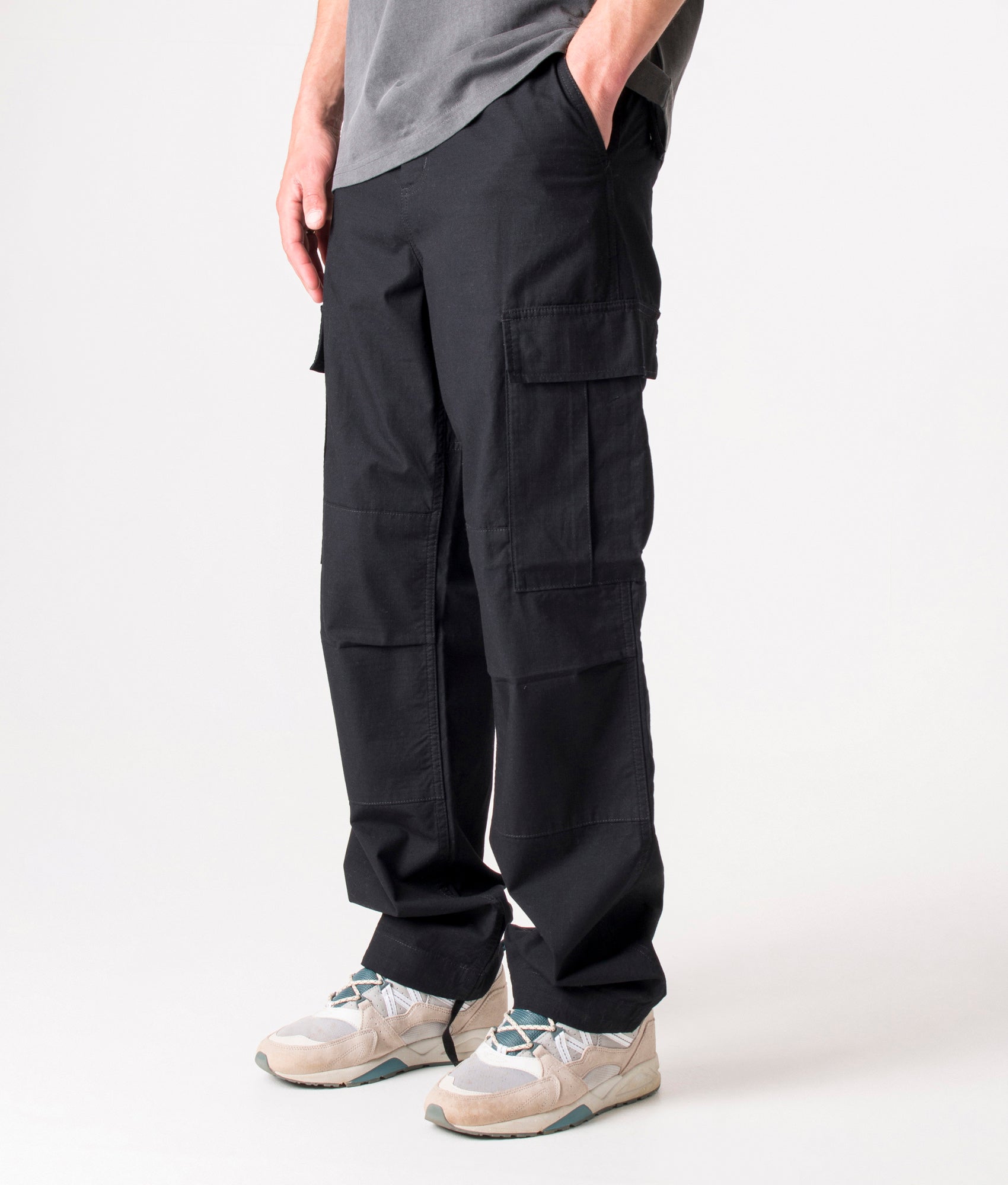 Carhartt Regular Fit Cargo Pants in Black at EQVVS Menswear. Angled front shot.