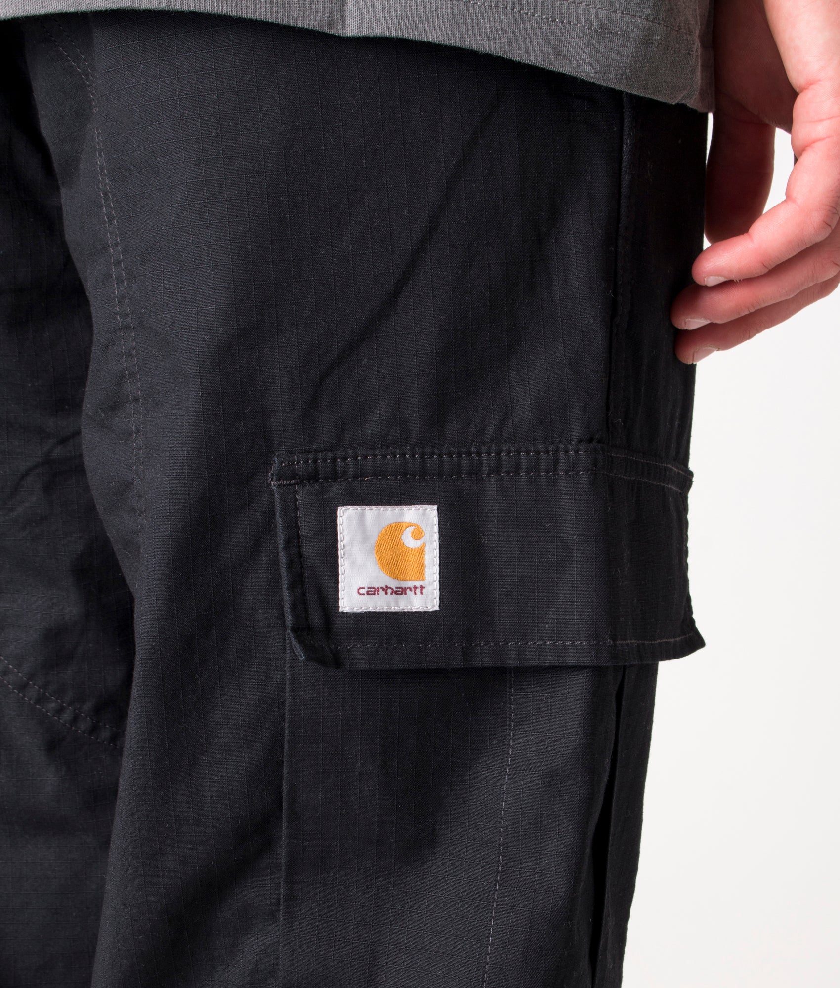 Carhartt Regular Fit Cargo Pants in Black at EQVVS Menswear. Detail shot.