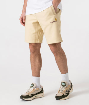 Carhartt WIP Relaxed Fit American Script Sweat Shorts in Rattan Yellow Angle Shot at EQVVS
