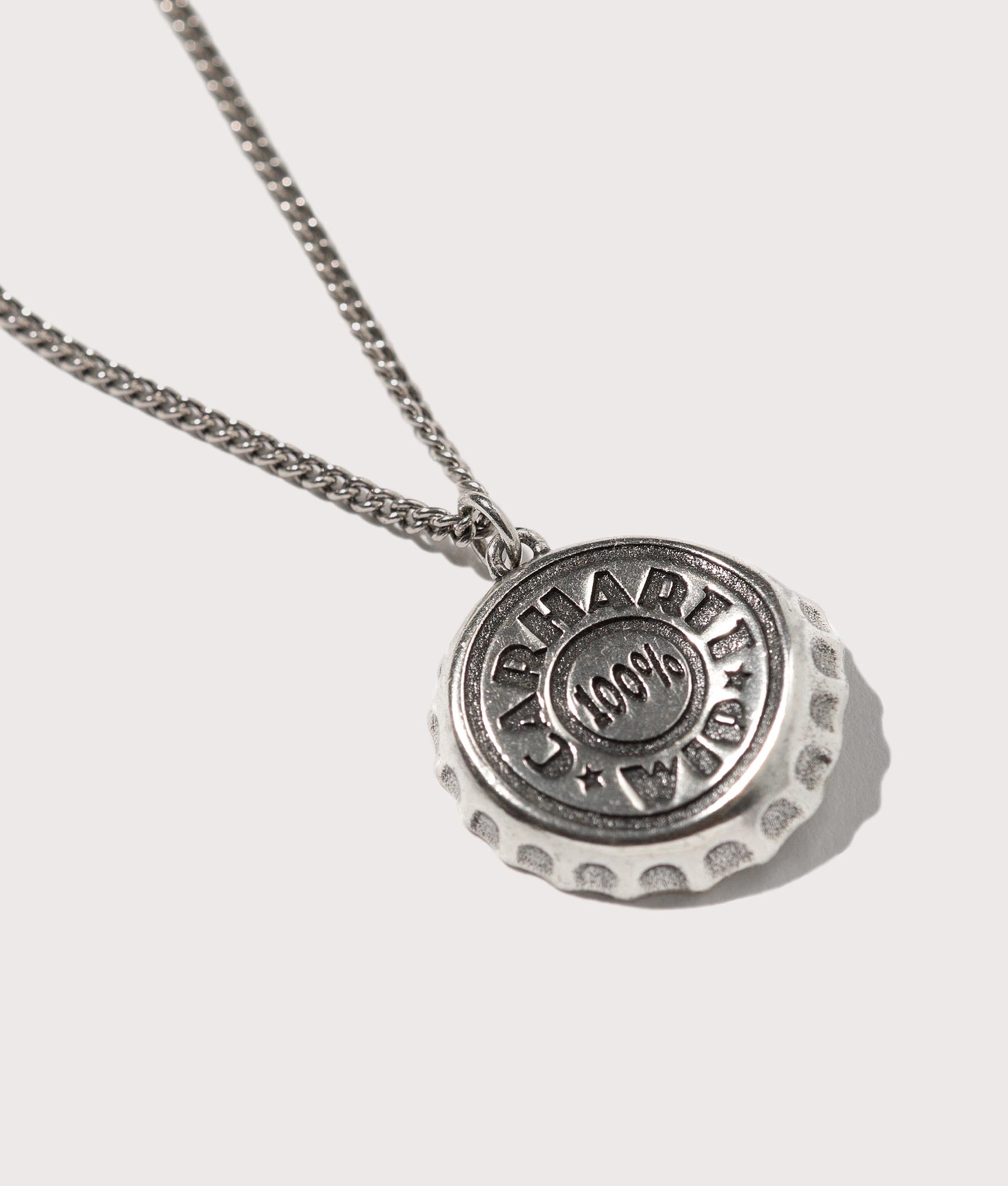 Bottle Cap Pendant in Silver by Carhartt. EQVVS Flat Shot.