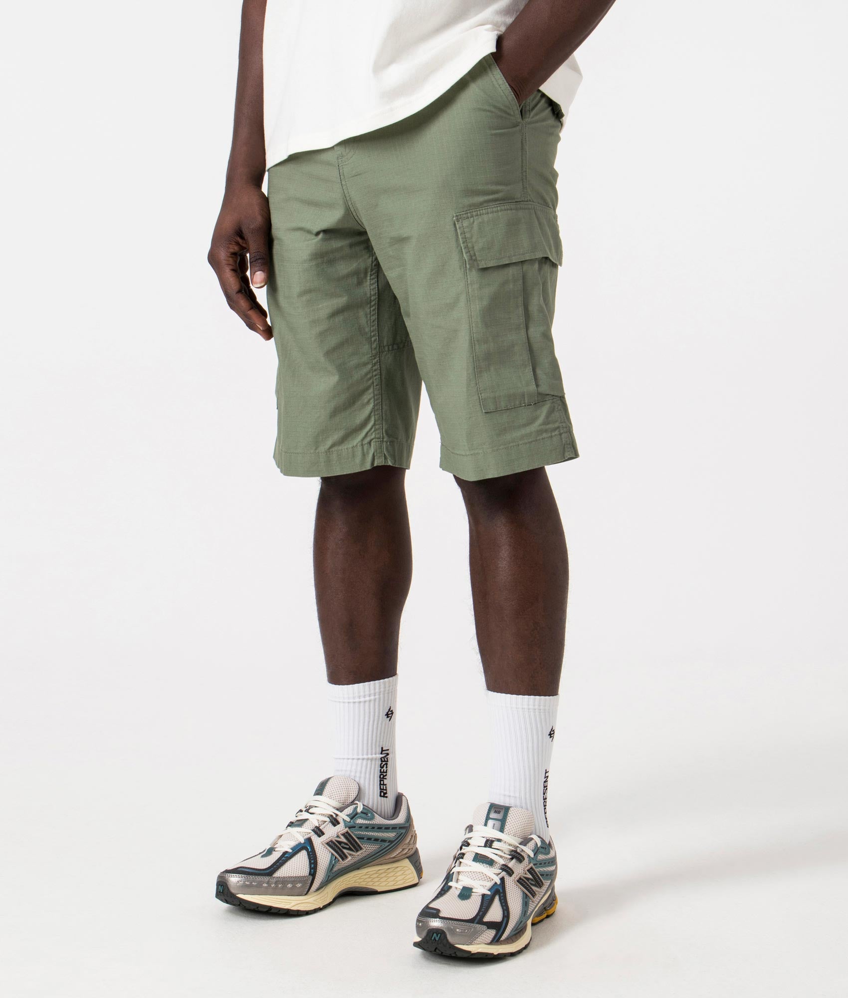 Carhartt WIP Regular Cargo Shorts in Park Green, 100% Cotton. Angle Model Shot at EQVVS