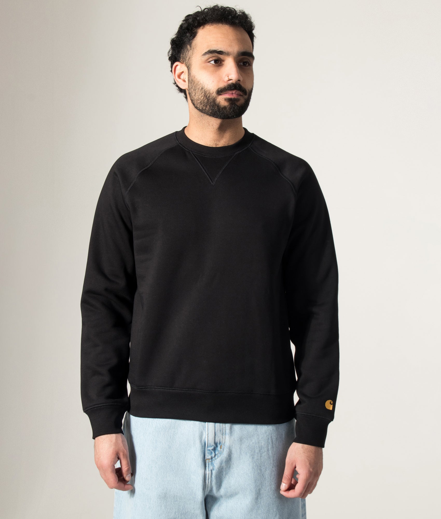 Carhartt WIP Chase Sweatshirt in Black/Gold at EQVVS Menswear. Model front shot.