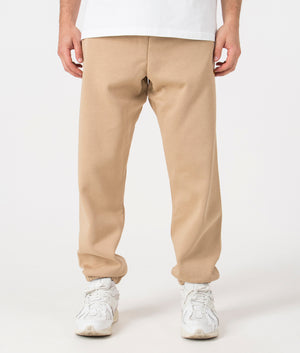 Carhartt WIP Relaxed Fit Chase Joggers in Sable/Gold. Front angle model shot at EQVVS.