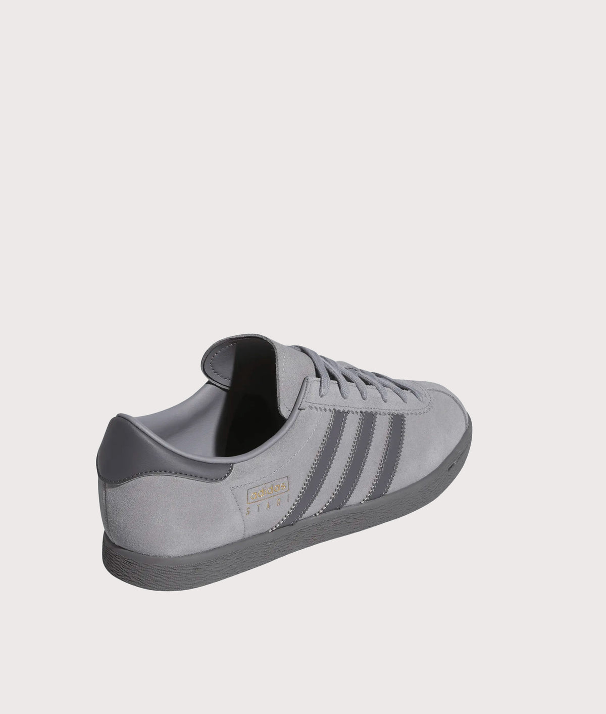 adidas Originals Stadt Trainers in Grey Three, Grey Five and Gold Metallic at EQVVS Menswear. Angled back shot.