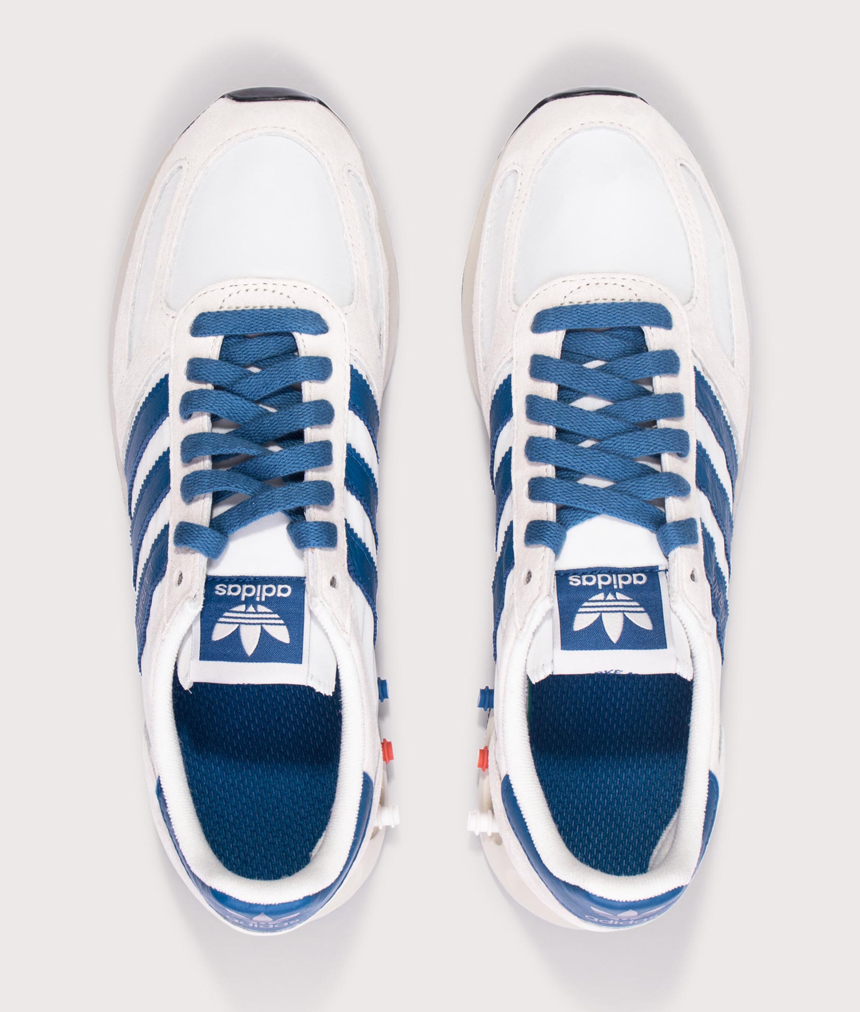 Adidas Originals LA Trainers in Off White, Dark Marine and Crystal White at EQVVS Menswear. Above shot.