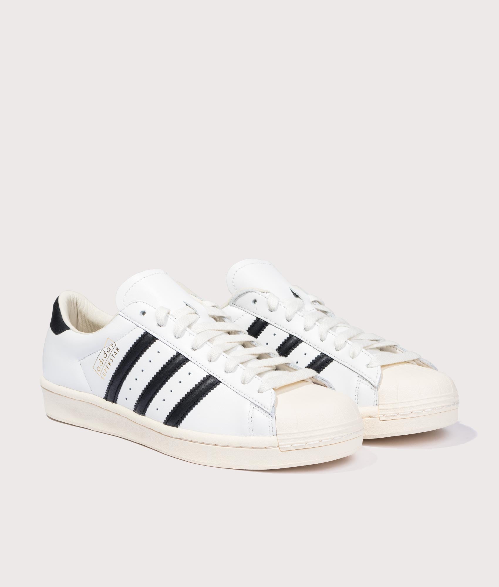 adidas Originals Superstar Vintage Trainers in Cloud White, Core Black and Cream White at EQVVS Menswear. Angled front shot.
