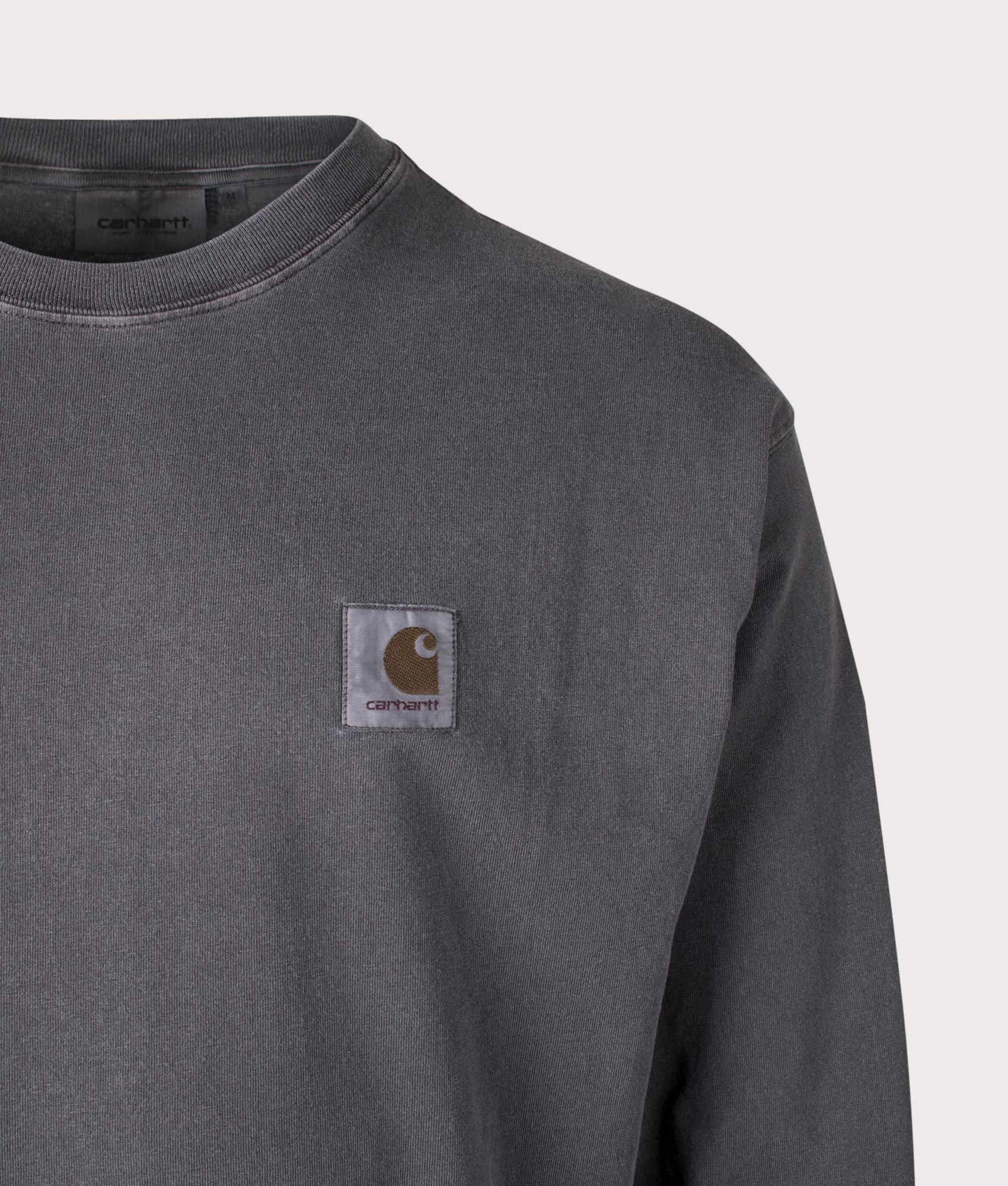 Carhartt WIP Relaxed Fit Long Sleeve Nelson T-Shirt in Graphite, 100% Cotton at EQVVS. Close-up shot. 