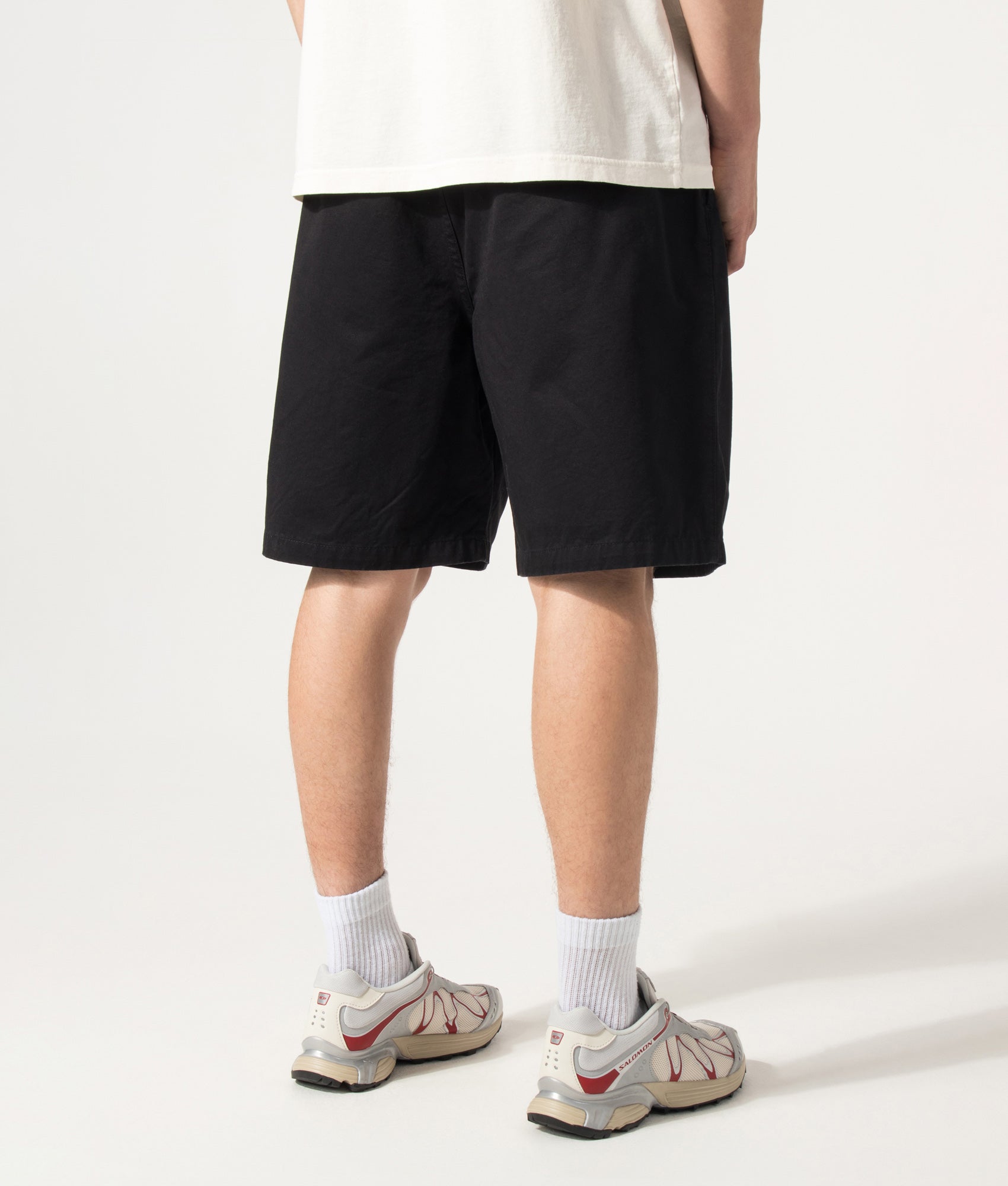 Carhartt WIP Marv Shorts in Stone Washed Black at EQVVS Menswear. Angled model back shot.