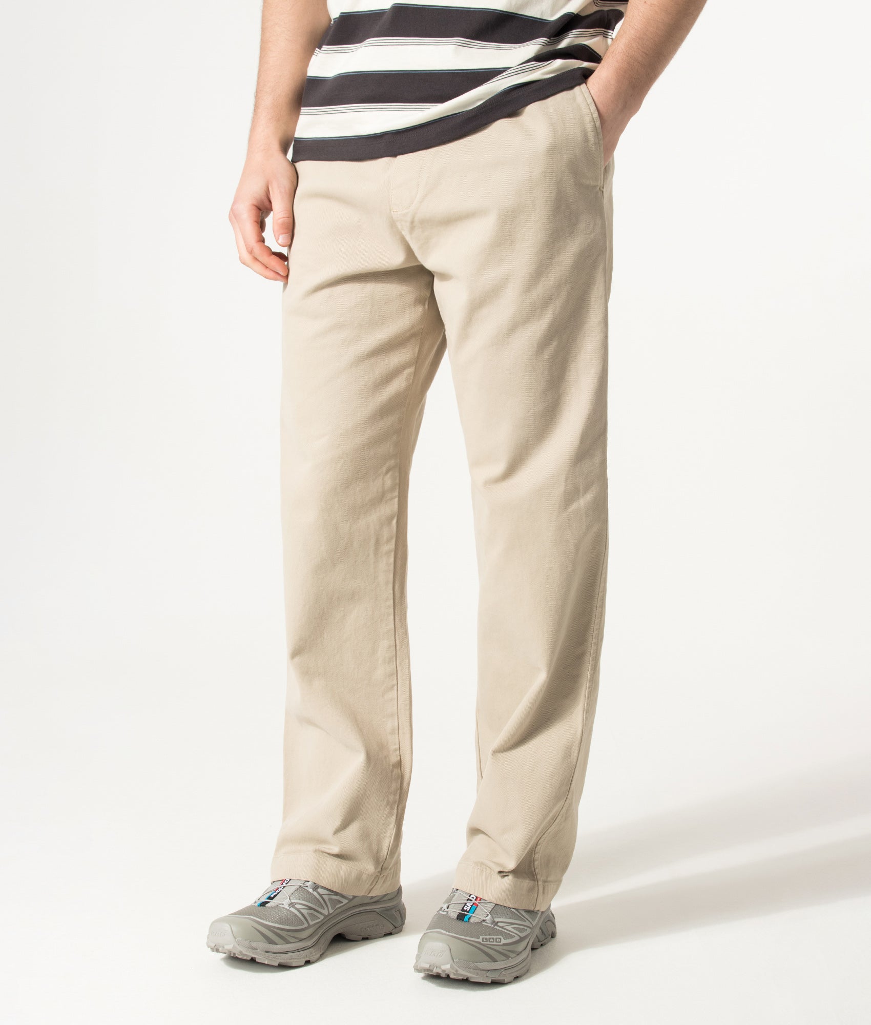 Carhartt WIP Relaxed Fit Floyde Pants in Wall at EQVVS Menswear. Angled model front shot.