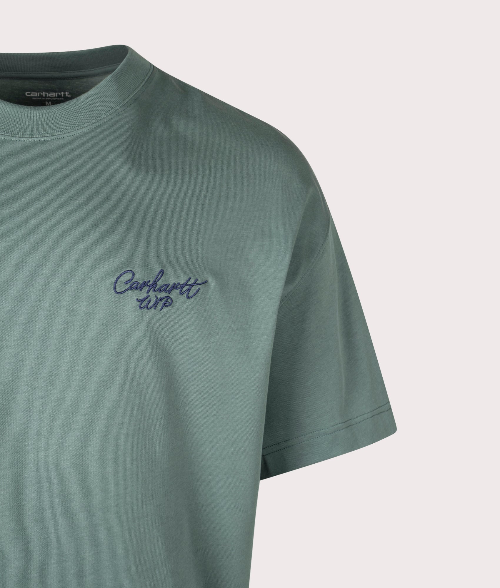 Carhartt WIP Boxy Loose Fit Signature Script T-Shirt in Silver Pine/Jupiter at EQVVS Menswear. Detail shot.