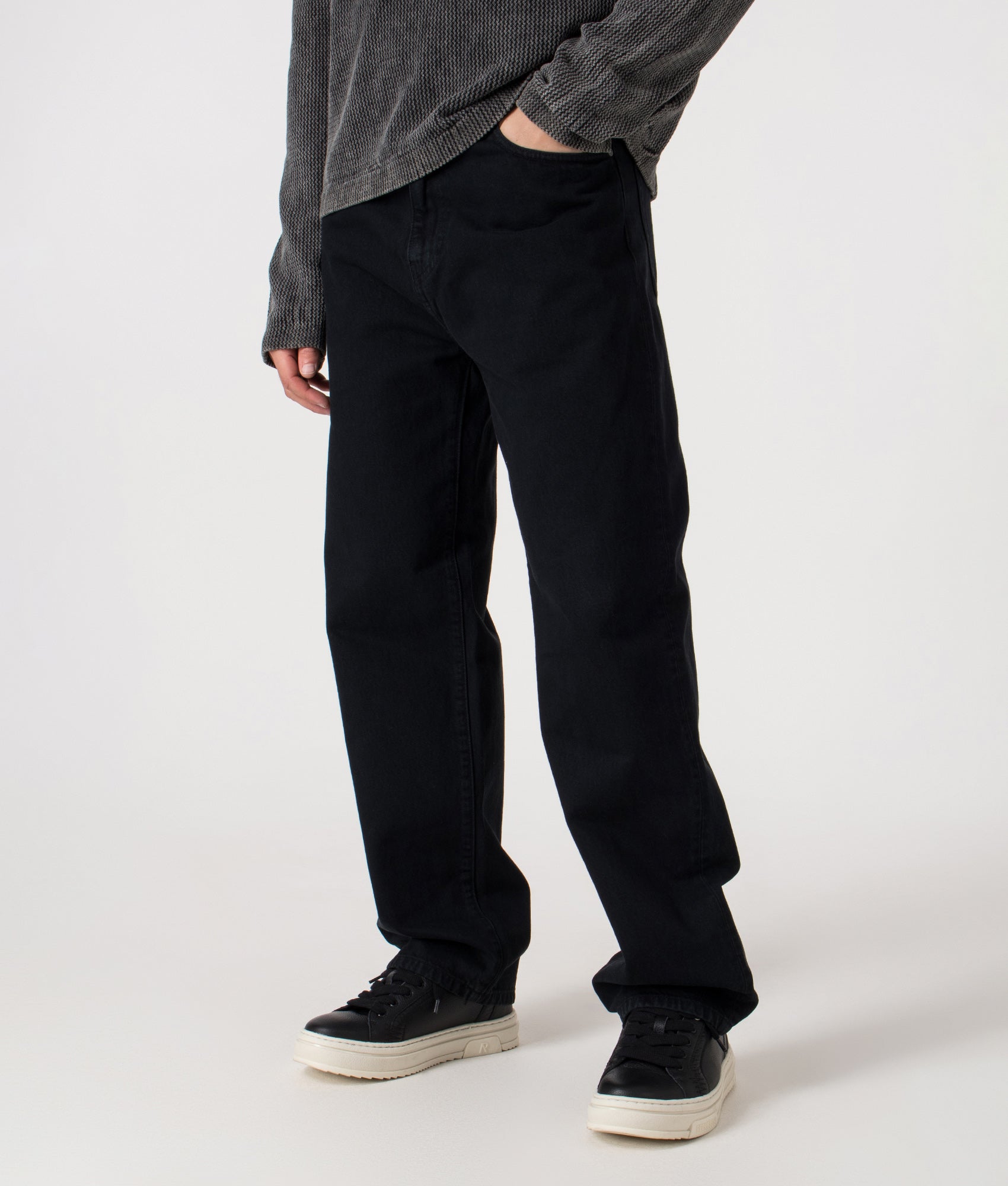 Carhartt WIP Relaxed Fit Aaron Pants in 01LF Blue at EQVVS Menswear. Model Angled shot.
