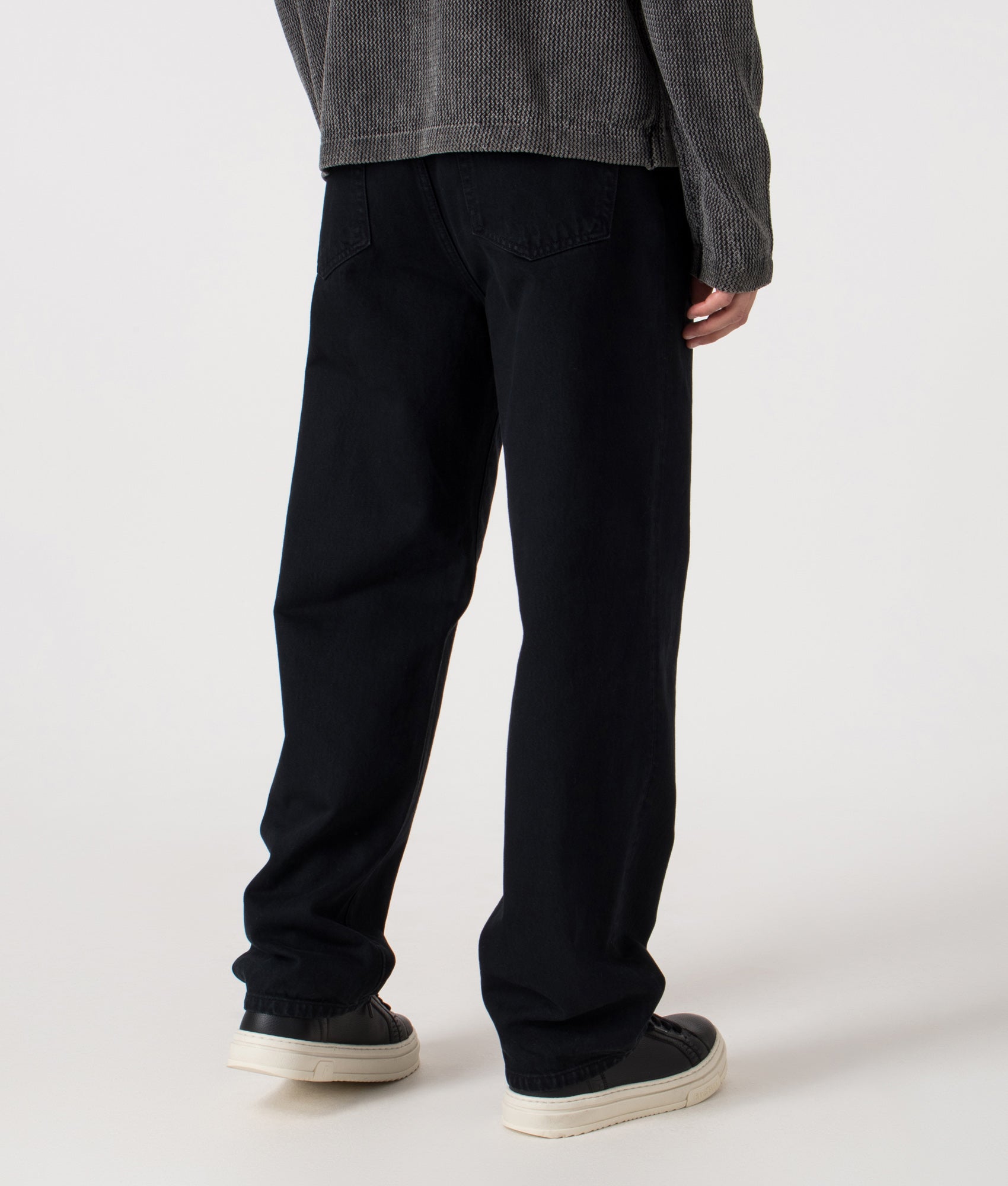 Carhartt WIP Relaxed Fit Aaron Pants in 01LF Blue at EQVVS Menswear. Model angled back shot.