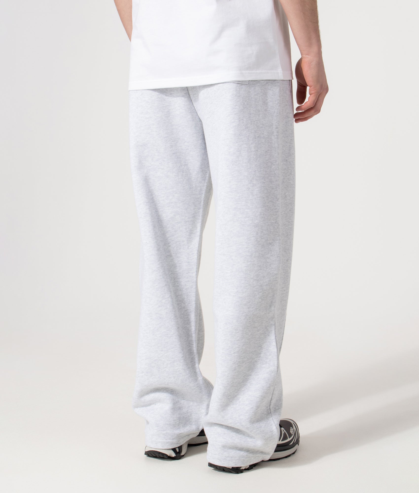 Carhartt WIP Relaxed Fit Pond Corps Sweatpants in Ash Heather at EQVVS Menswear. Model back shot.