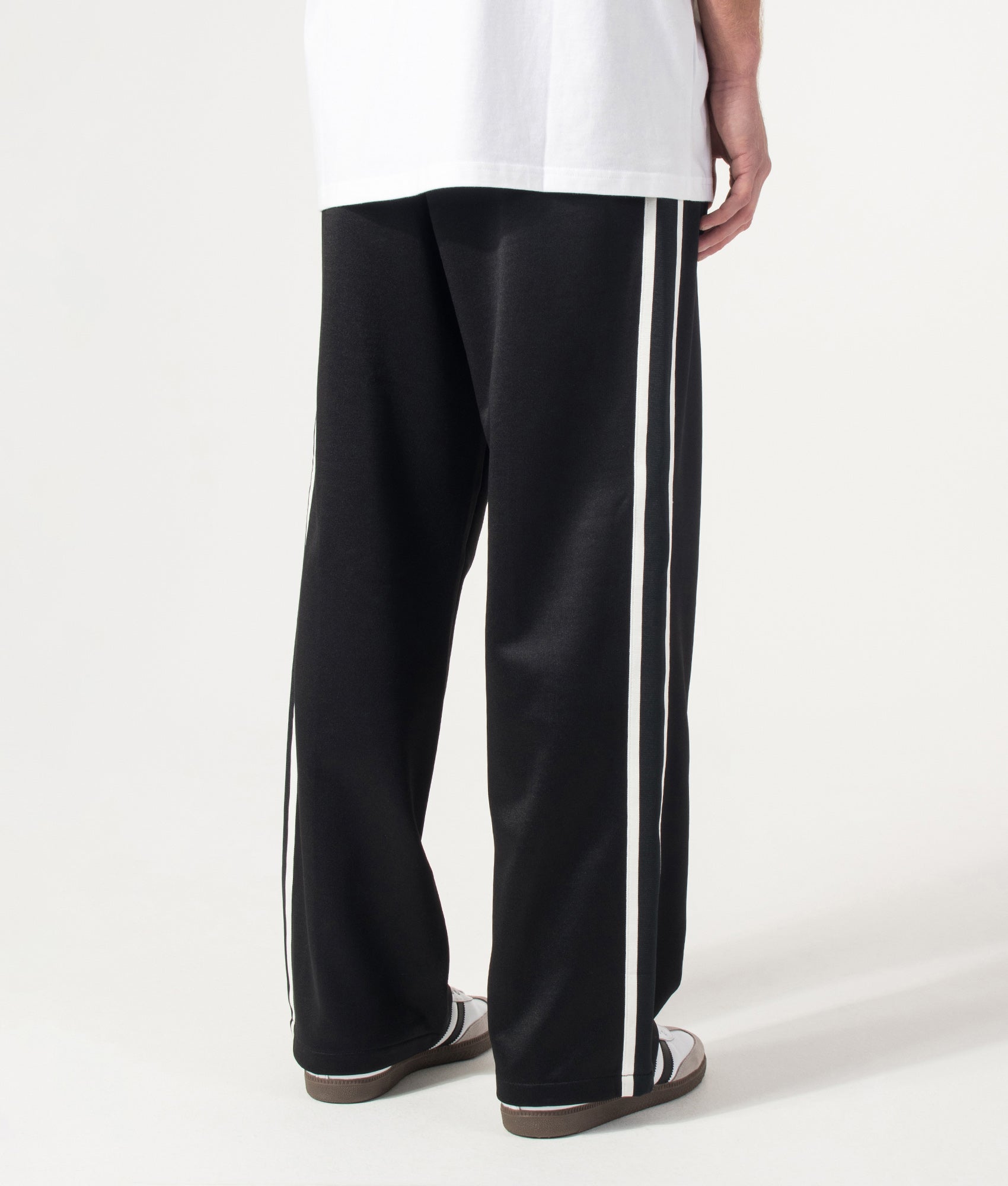 Carhartt WIP Relaxed Fit Bolar Sweat Pants in Black and Wax at EQVVS Menswear. Model back shot.