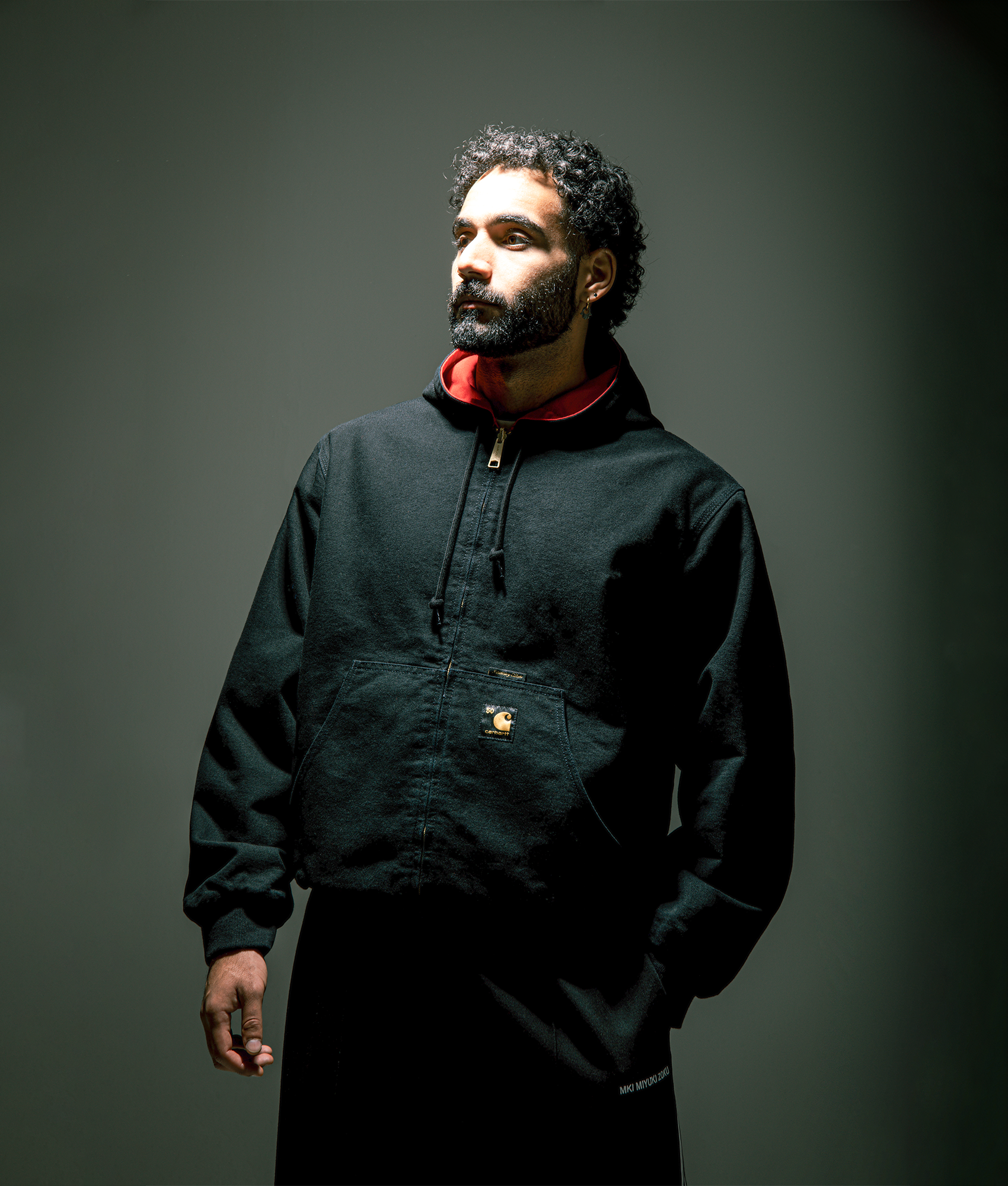 Carhartt WIP 50 Years Anniversary OG Active Canvas Jacket in Black/USA Red at EQVVS Menswear. Side A Campaign shot.