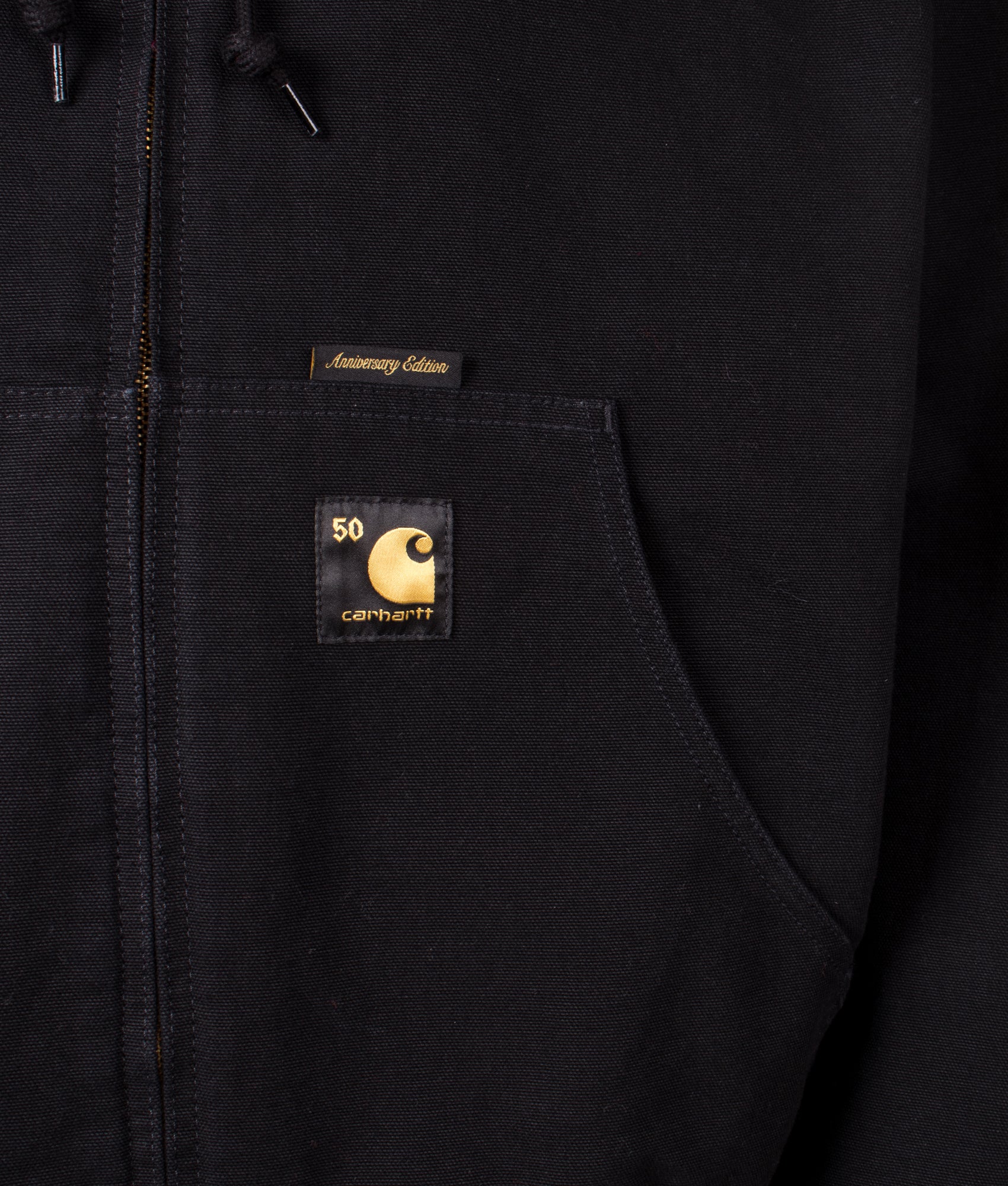 Carhartt WIP 50 Years Anniversary OG Active Canvas Jacket in Black/USA Red at EQVVS Menswear. Side A detail shot.