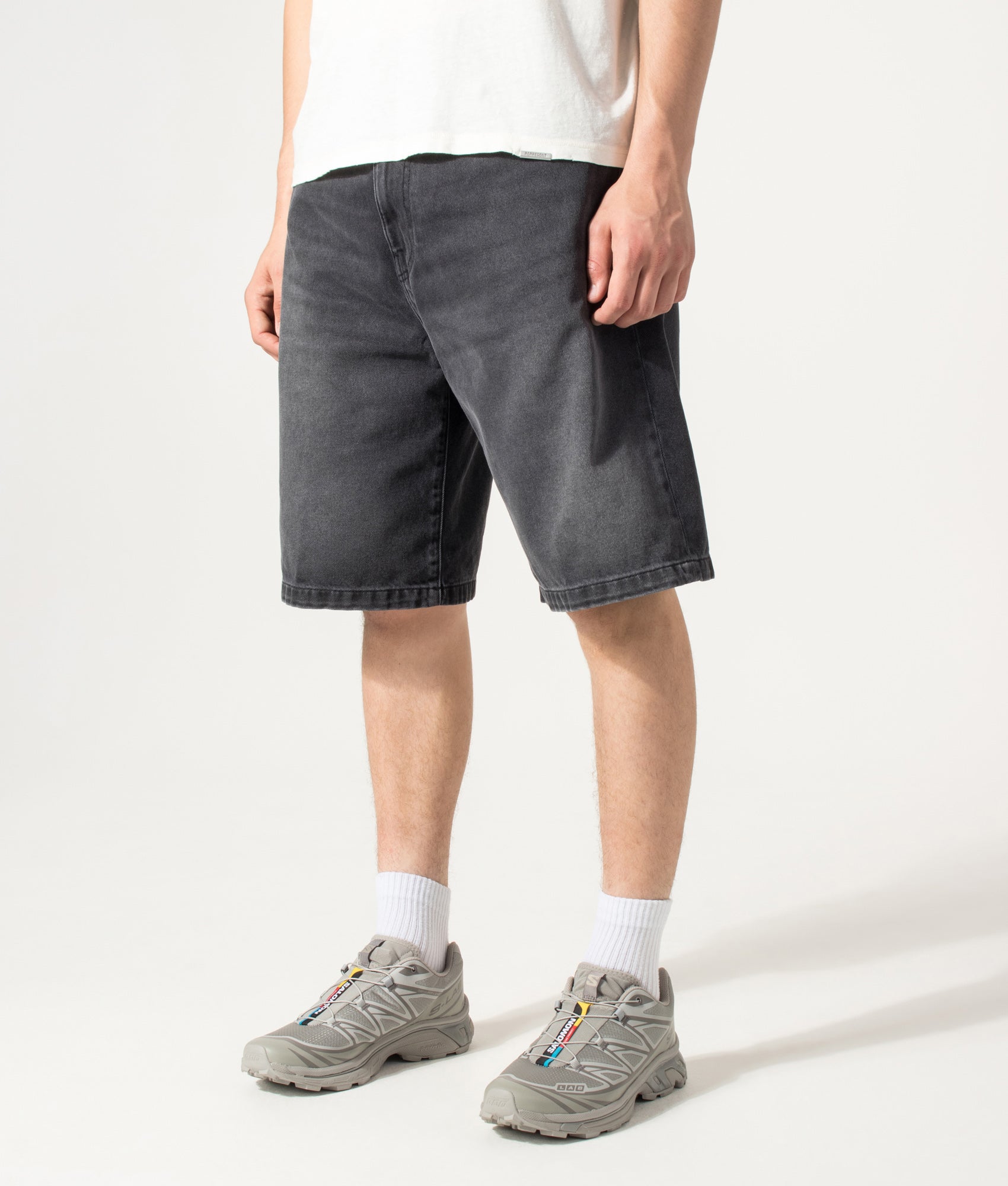 Carhartt WIP Loose Fit Landon Denim Shorts in Worn Bleached Black at EQVVS Menswear. Angled model front shot.