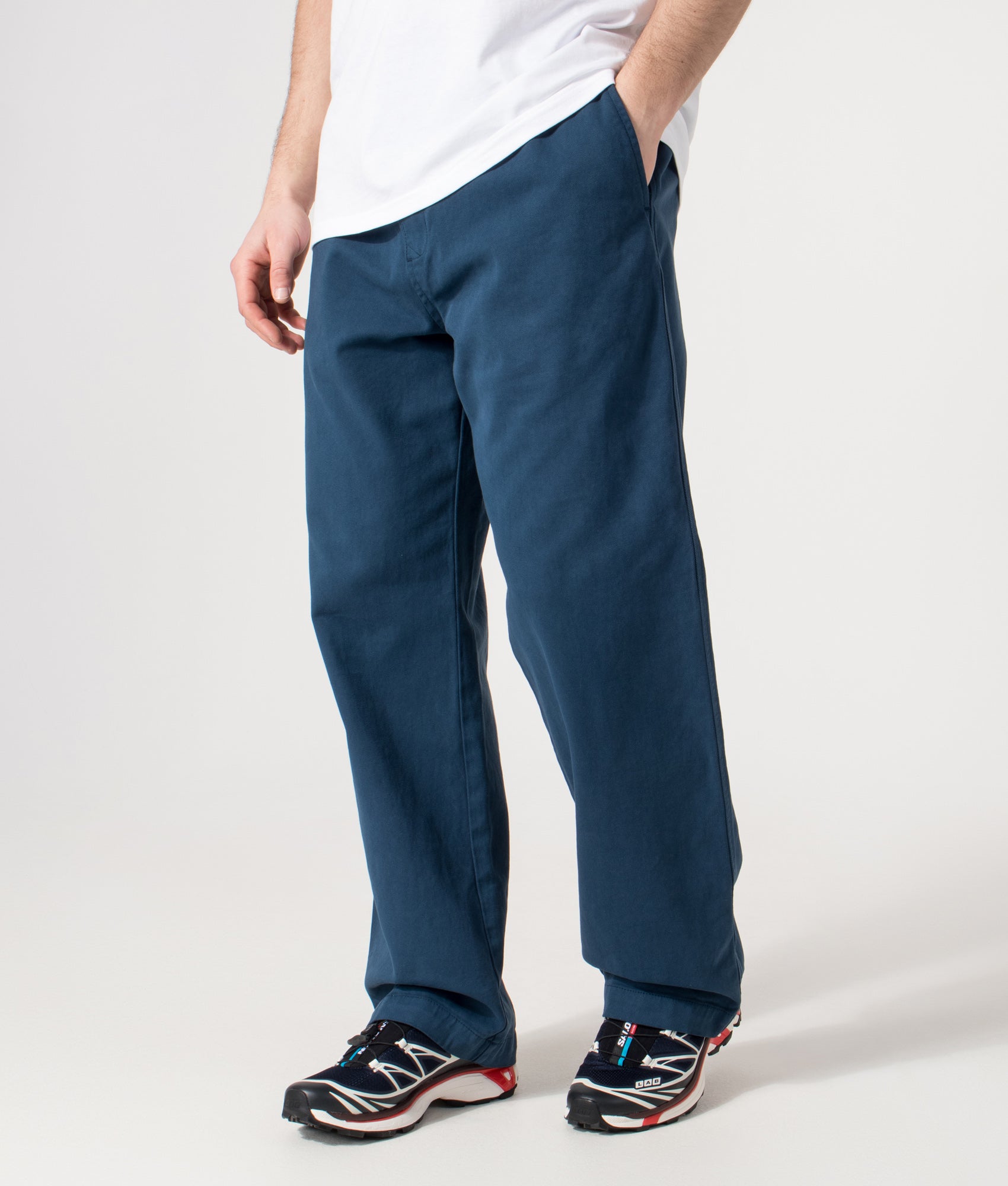 Carhartt WIP Relaxed Fit Floyde Pants  in Blue River at EQVVS Menswear. Angled model front shot.