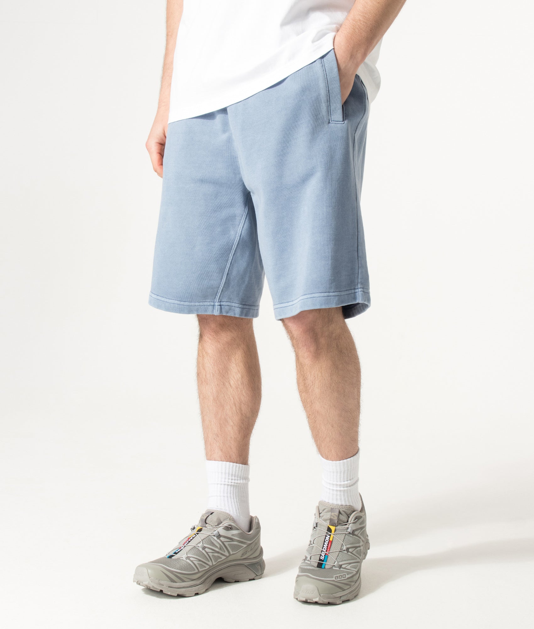 Carhartt WIP Balloon Fit Nelson Sweat Shorts in Gentle Blue at EQVVS Menswear. Angled model front shot.