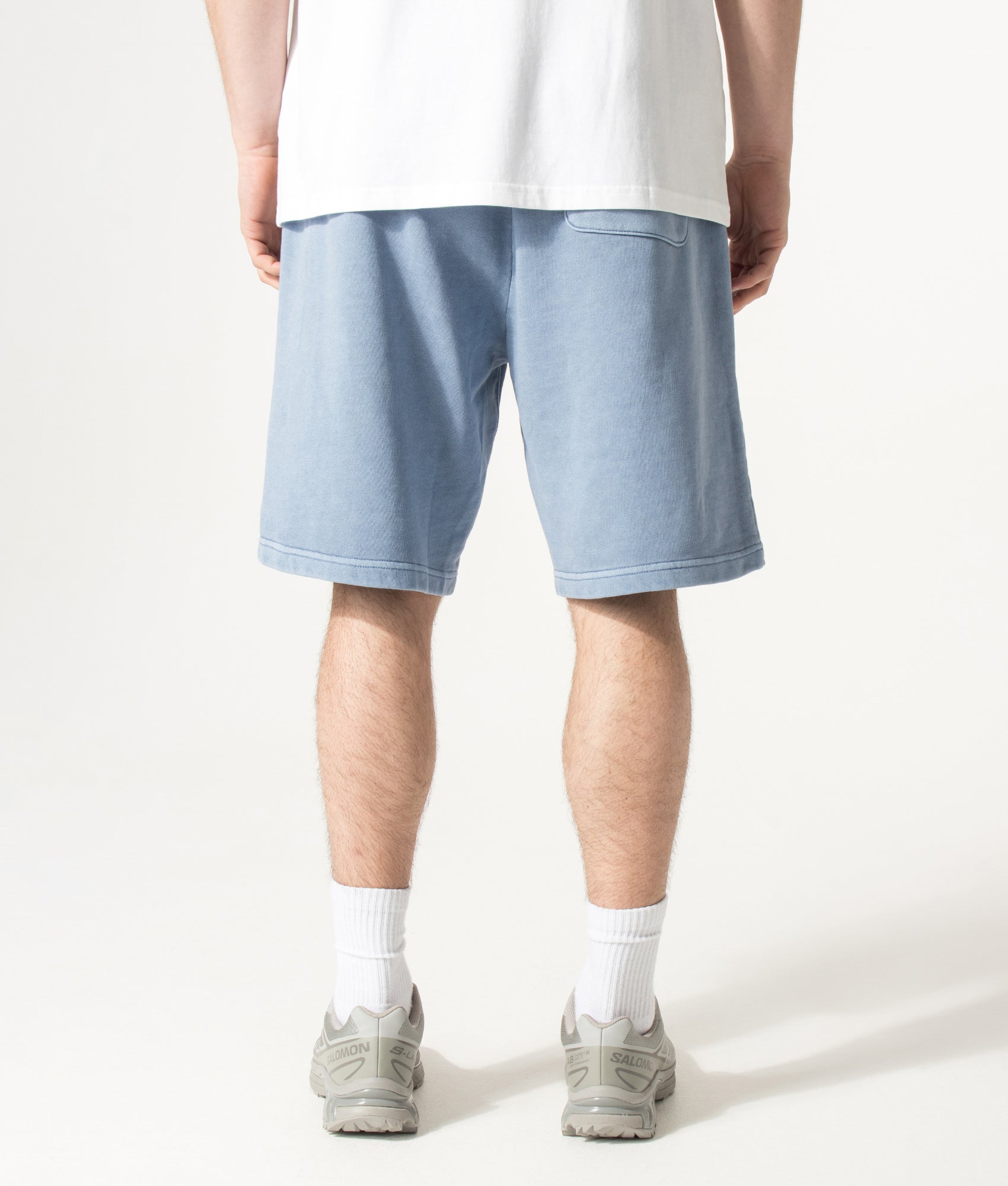 Carhartt WIP Balloon Fit Nelson Sweat Shorts in Gentle Blue at EQVVS Menswear. Model back shot.