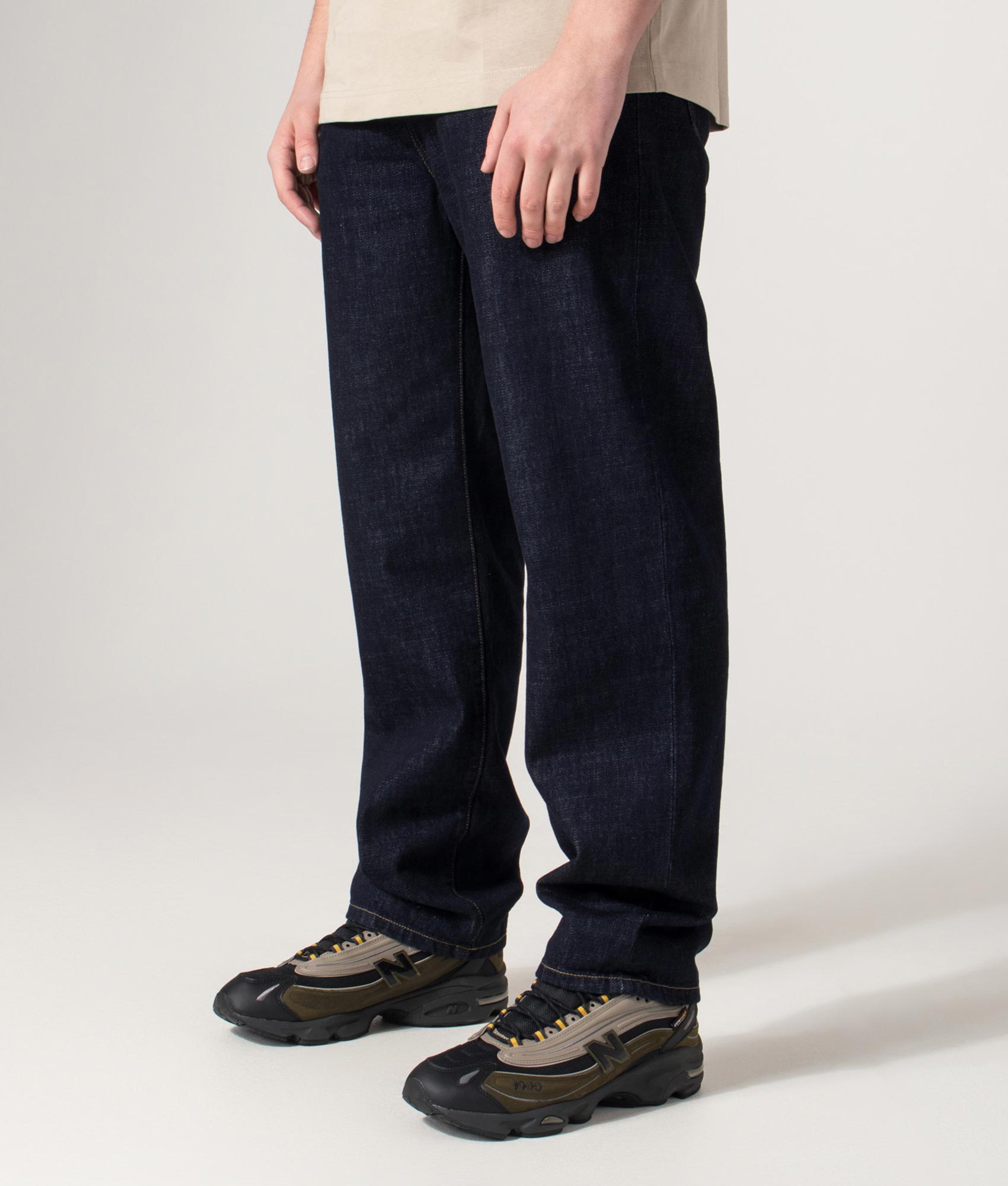Carhartt WIP Regular Fit Tapered Aaron Pants in Blue at EQVVS Menswear. Angled model shot.