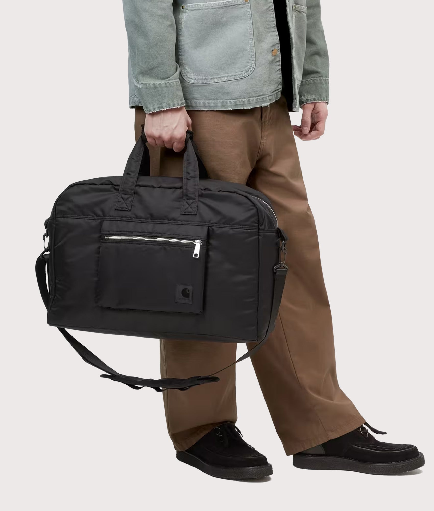 Carhartt WIP Otis Weekend Bag in Black at EQVVS Menswear. Model shot.