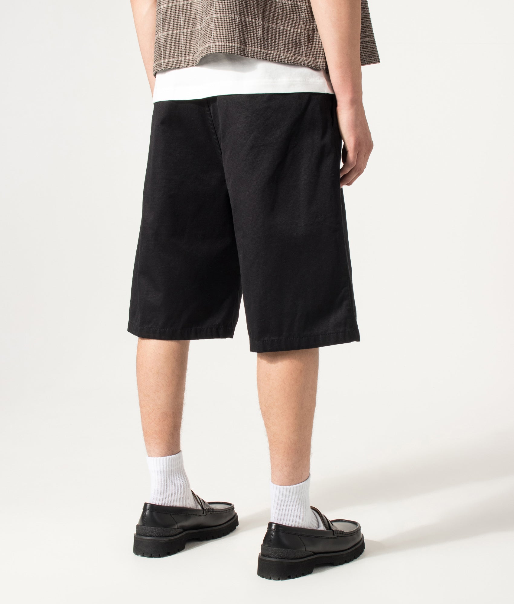 Carhartt WIP Loose Fit Brader Shorts in Black at EQVVS Menswear. Angled model back shot.