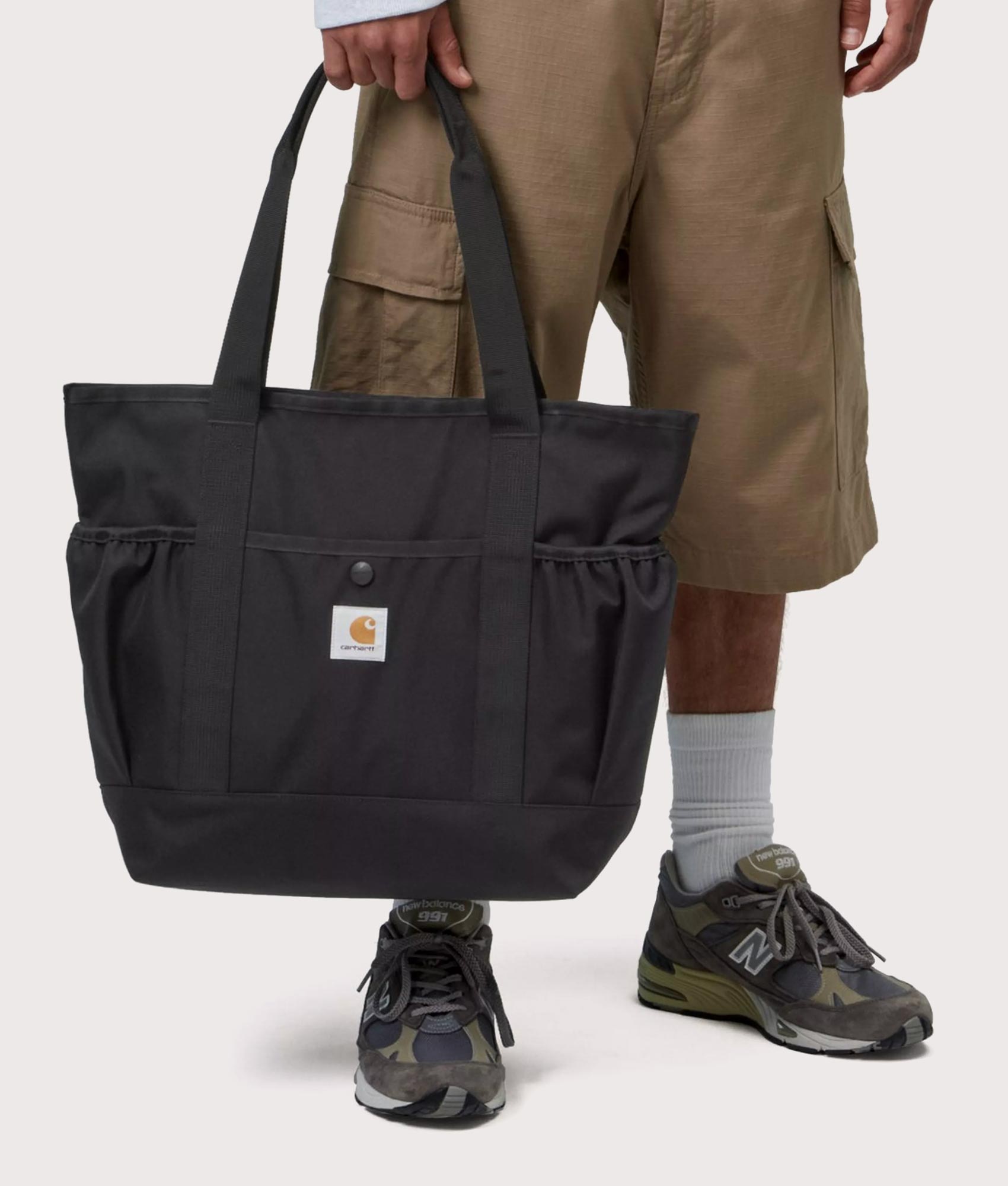Carhartt WIP Clapton Tote Bag in Black at EQVVS Menswear. Model front shot.