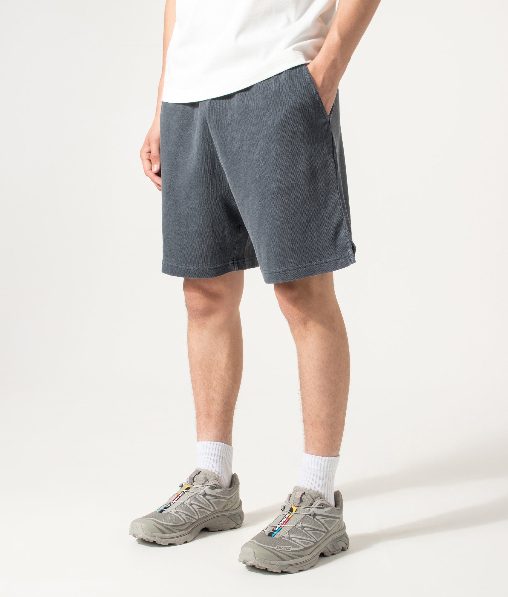 Carhartt WIP Balloon Fit Harper Sweat Shorts in Carbon at EQVVS Menswear. Angled model front shot.