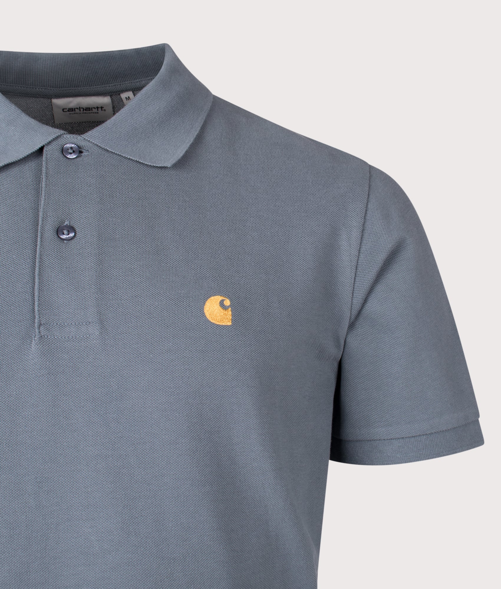 Carhartt WIP Relaxed Fit Chase Pique Polo Shirt in Cozy Blue and Gold at EQVVS Menswear. Detail shot.