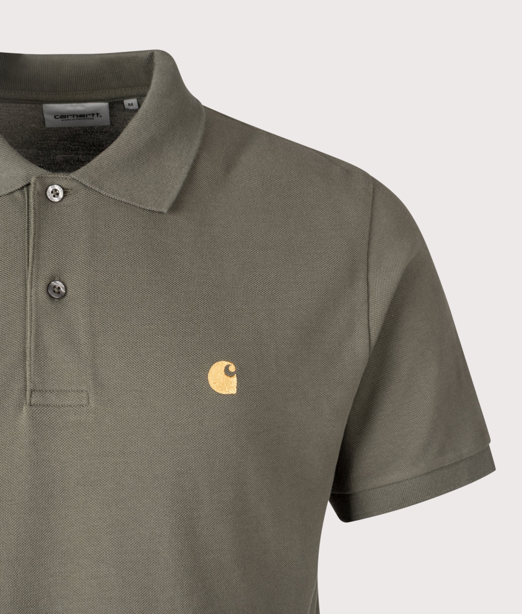 Carhartt WIP Relaxed Fit Chase Pique Polo Shirt in Leaf and Gold at EQVVS Menswear. Detail shot.